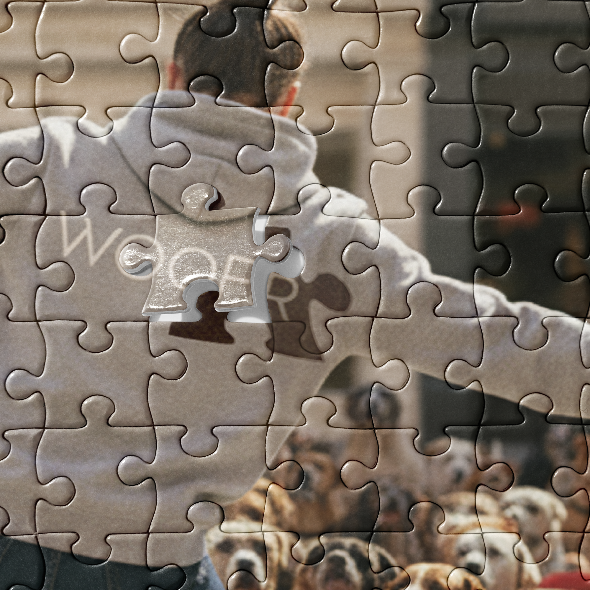 Puzzle - Unleashed - Close-up detail of jigsaw puzzle pieces. Highlights the grey hoodie texture and the text 'WOOFR'.