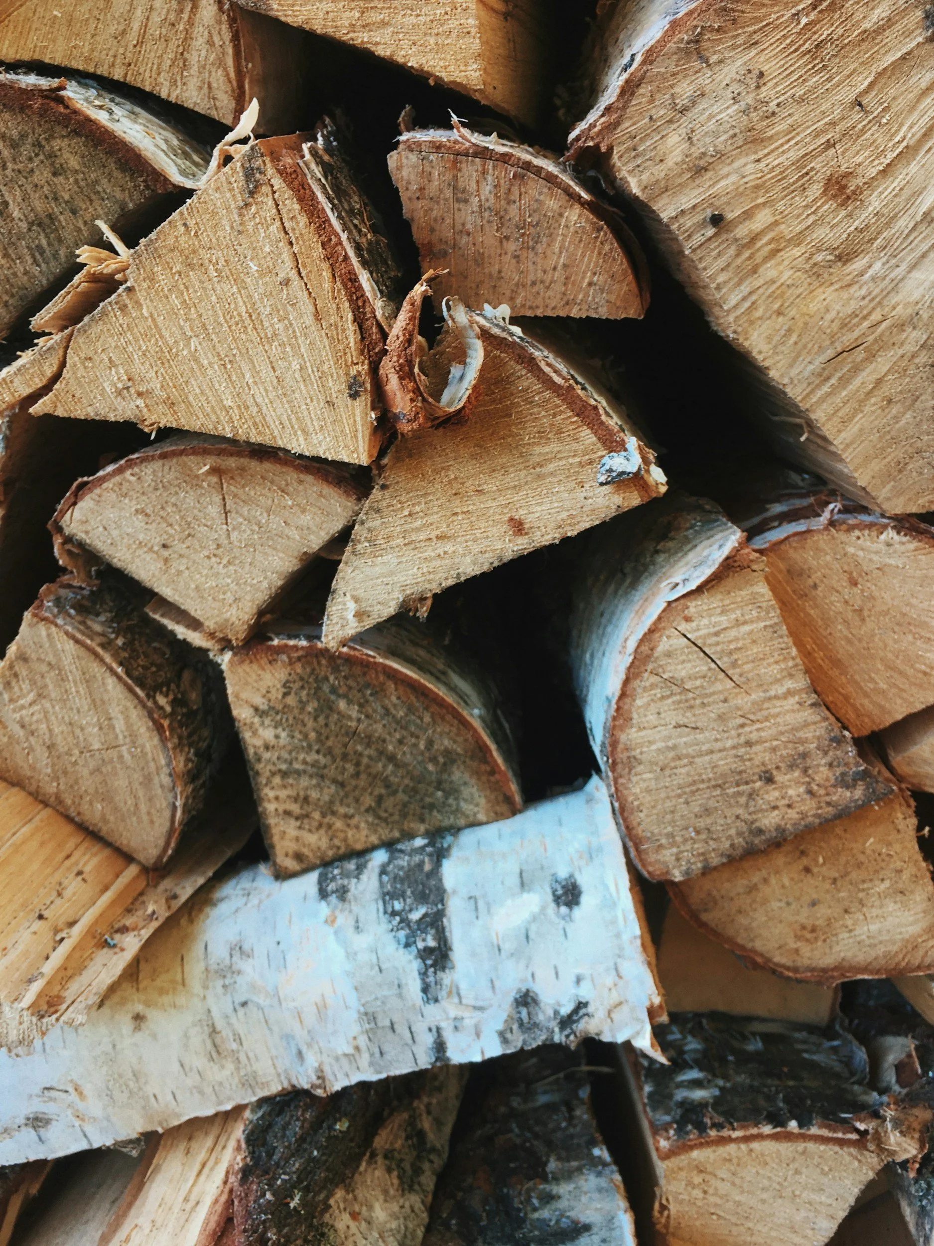 Stacked firewood logs with visible wood grain and bark.