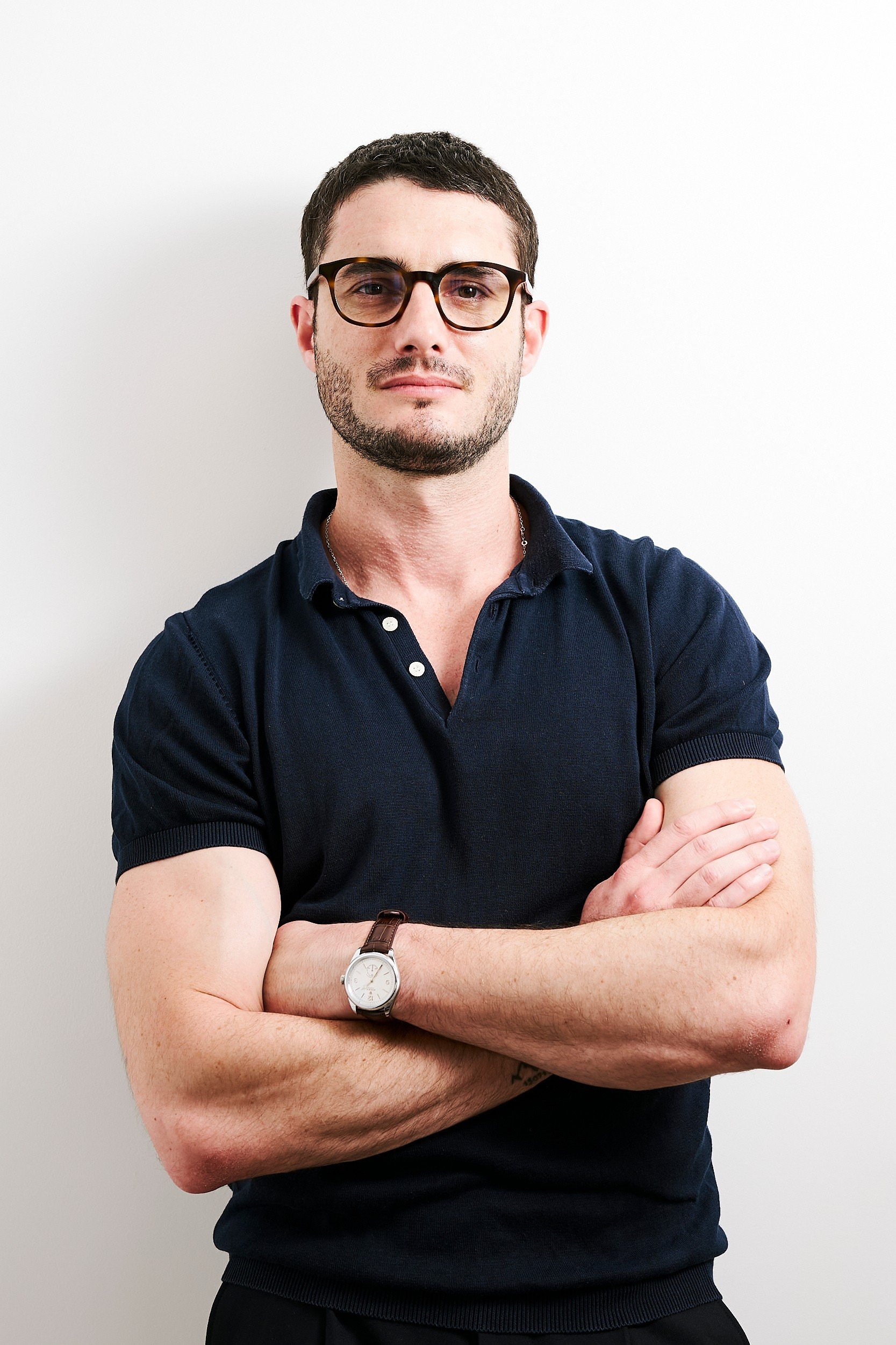 Portrait de Tom Palmieri Rambaud, co-fondateur du cabinet de conseil F&B Chow Republic, portant des lunettes et un polo bleu marine.