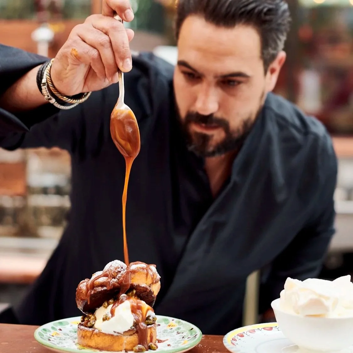 Le chef Jeffrey Cagnes versant un coulant au caramel sur une pâtisserie lors d'une activation culinaire exclusive au festival Big Fest.