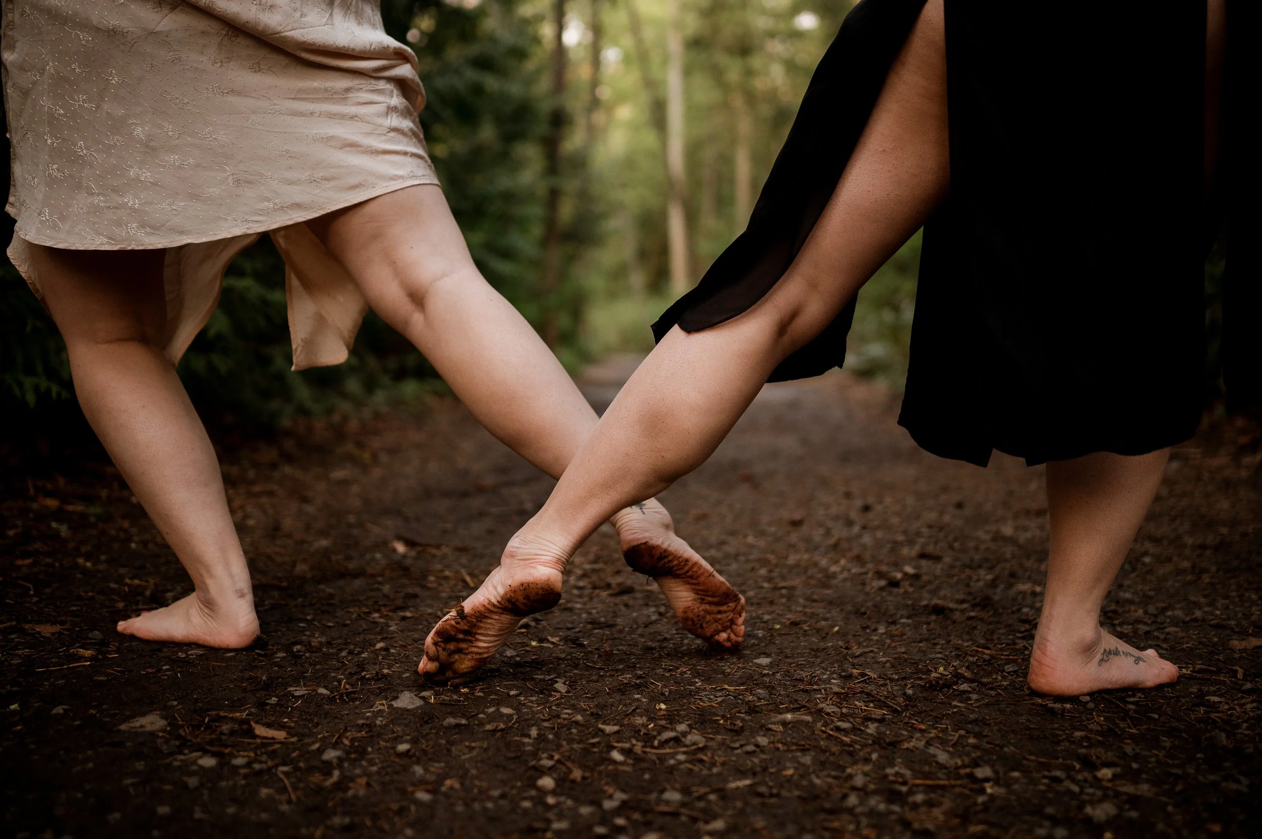 two bare feet crossing on a dirt path