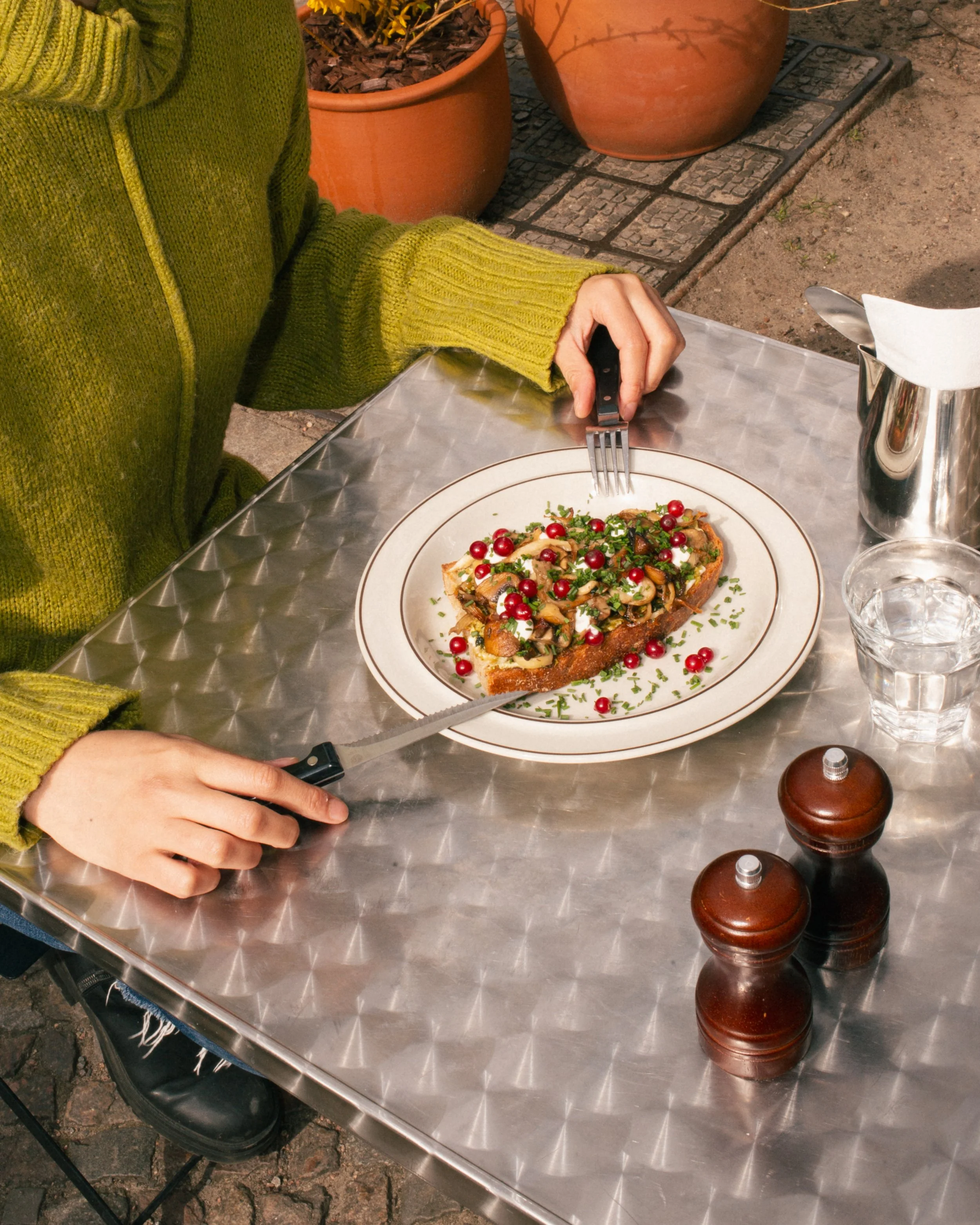 The best vegan mushroom toast in Berlin served on our beautiful sunlit terrace, featuring sourdough bread, sautéed mushrooms, and fresh herbs in a cozy outdoor cafe setting.