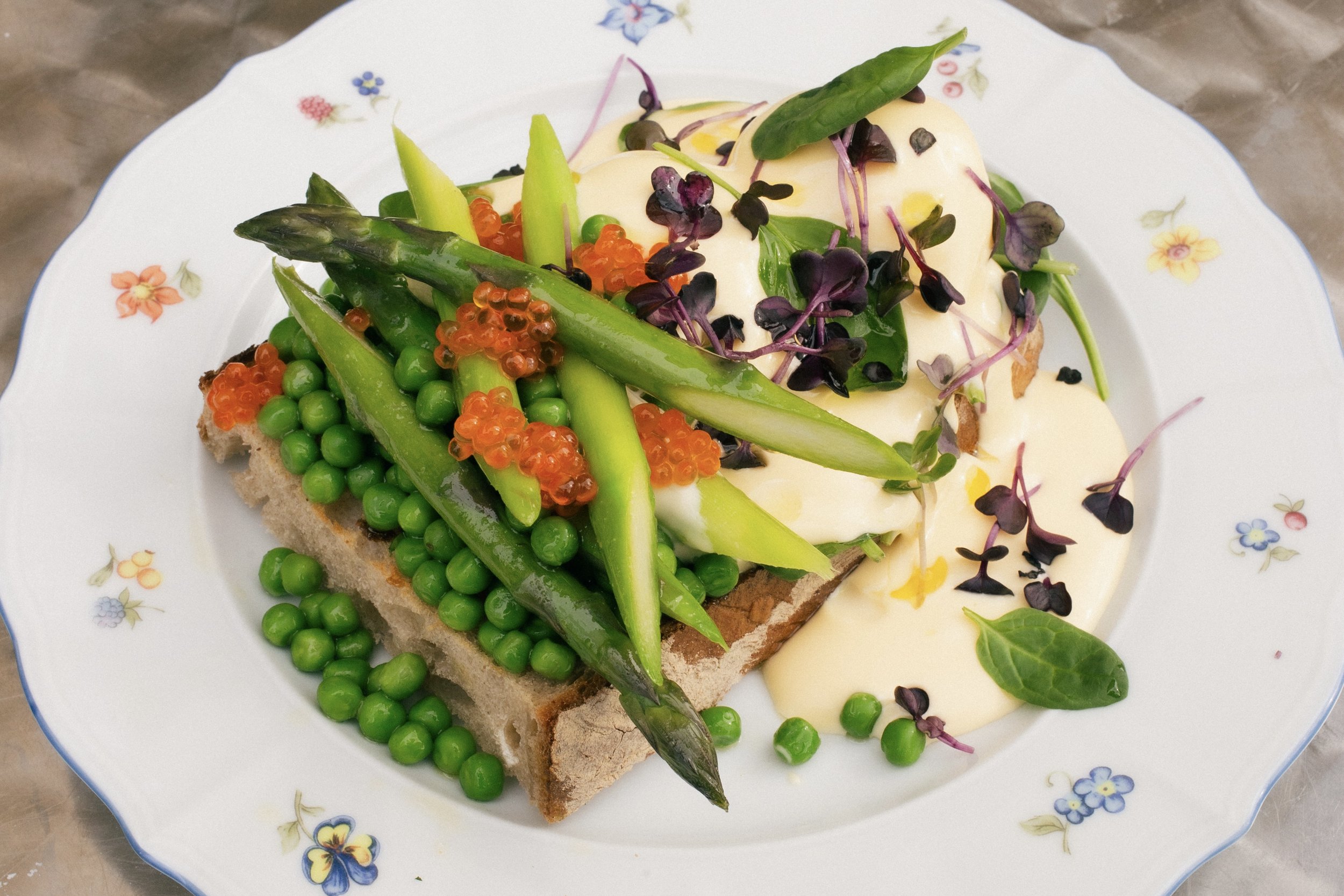 Im Kern ist das Gericht ganz einfach: pochierte Eier, Sauce Hollandaise, Spinat und weiche Brioche.