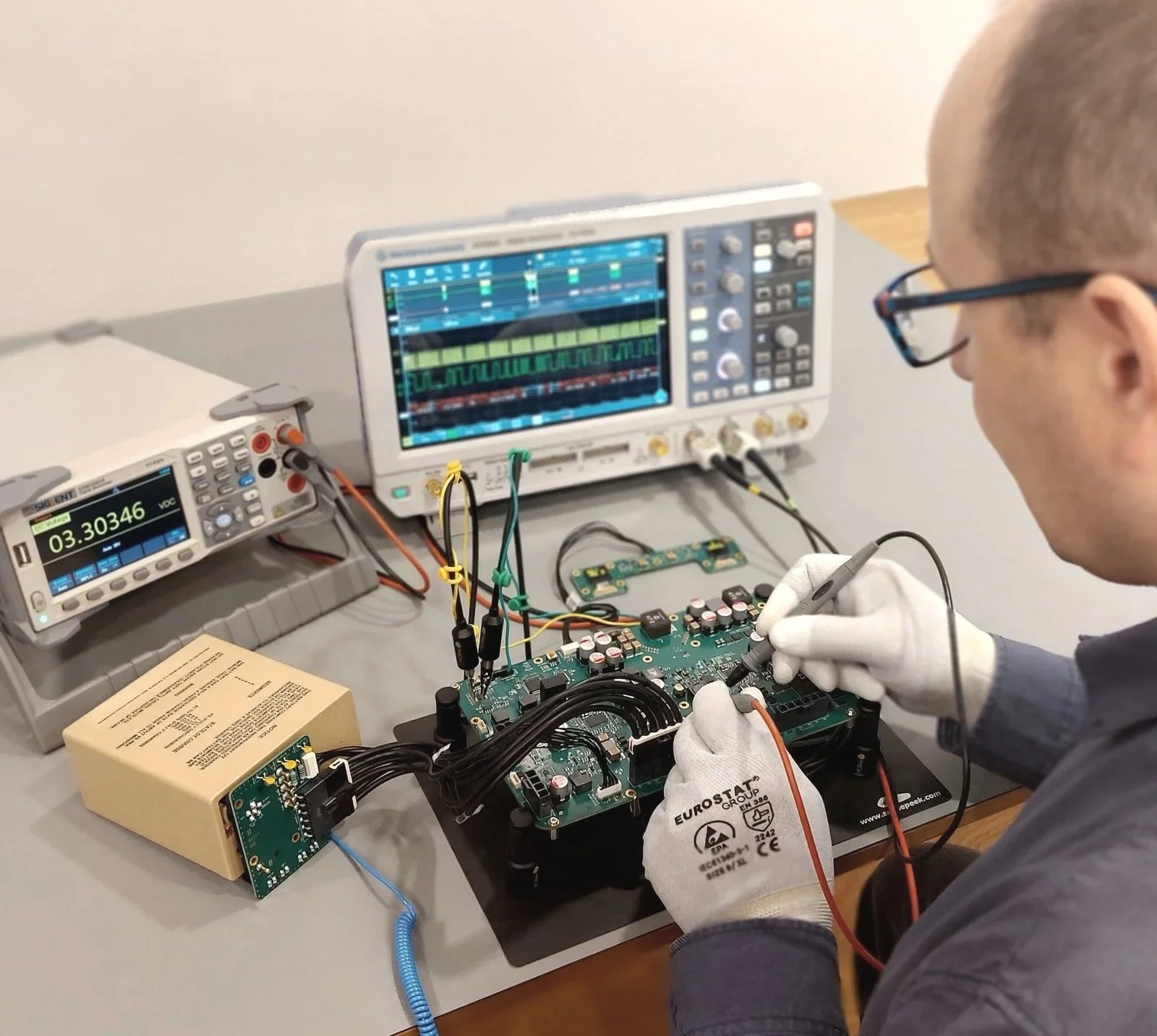 Electronic engineer measuring on custom PCB board