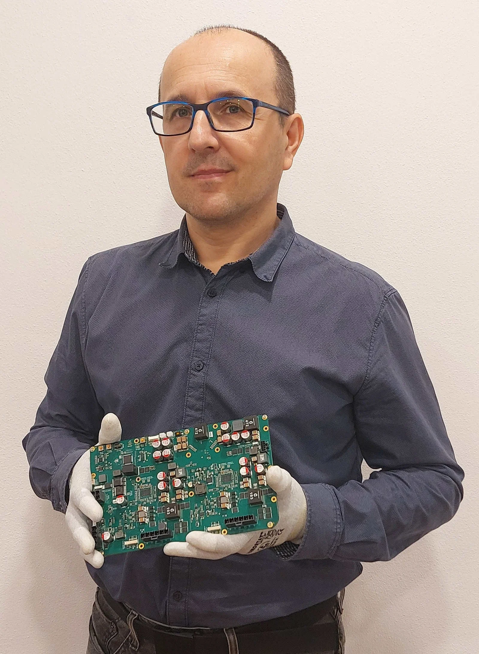 Engineer Marek Gunis with custom electronic board in the hands