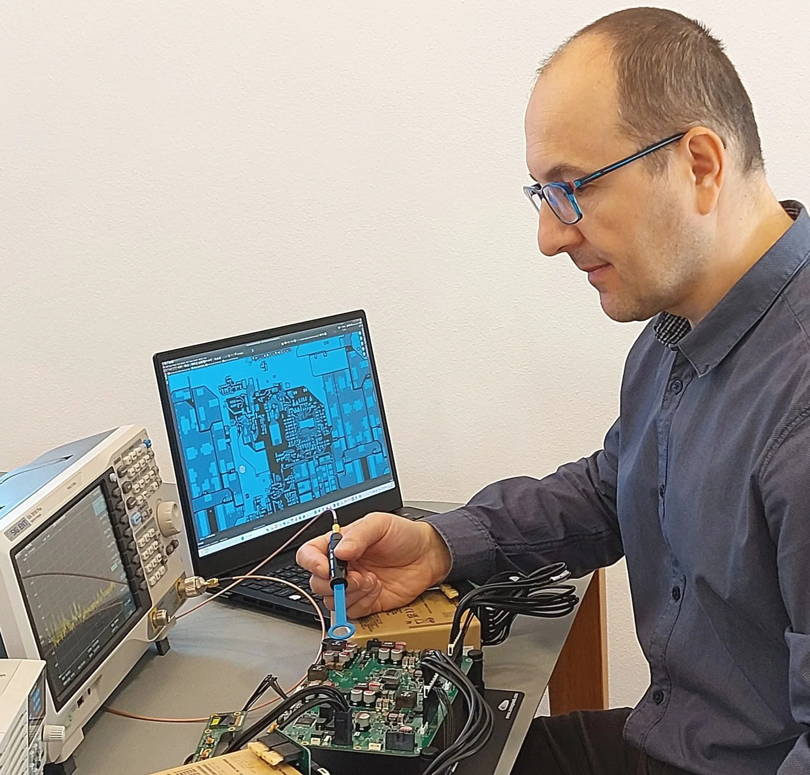 Engineer Marek Gunis measuring on custom setup EMC with near-field probe and spectrum analyzer