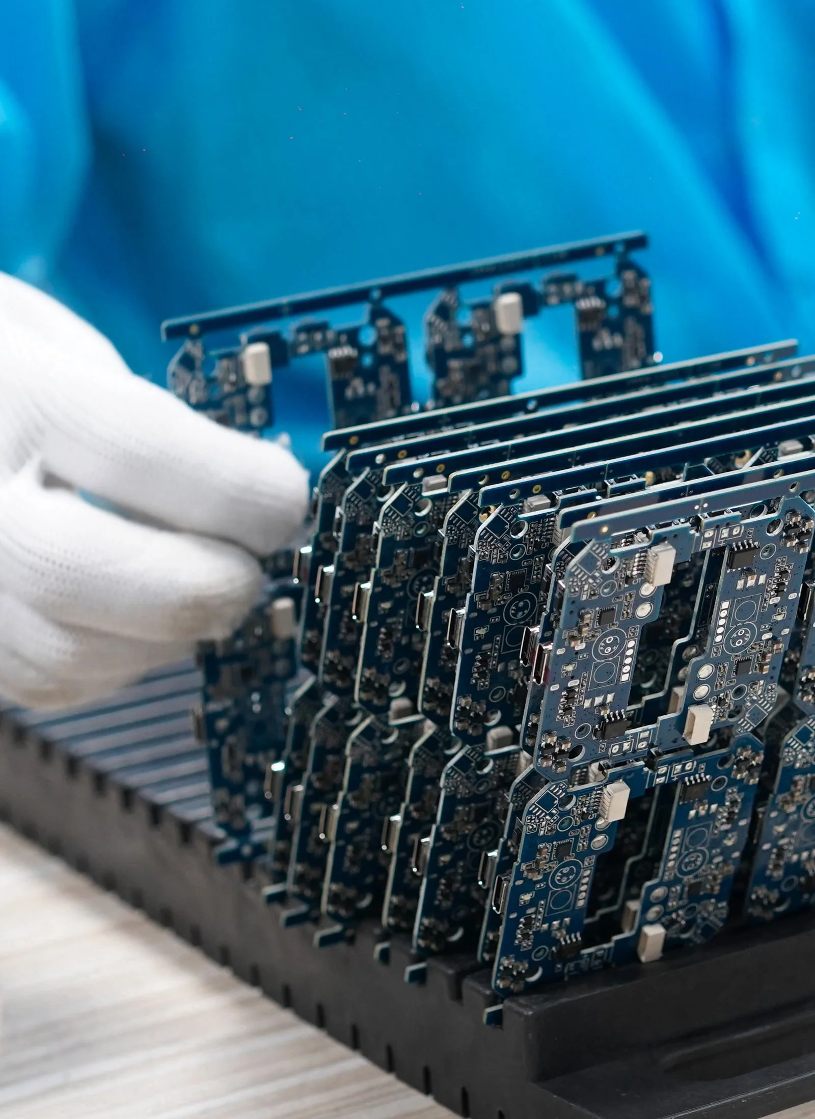 Production operator sorting electronic boards PCBs after SMT assembling placed in the tray