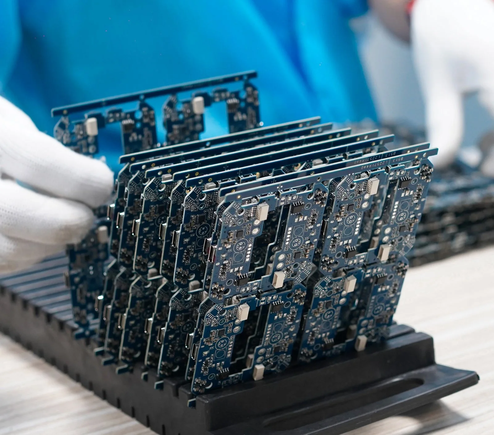 PCBs assembled in production line placed on the tray with human sorting them in gloves