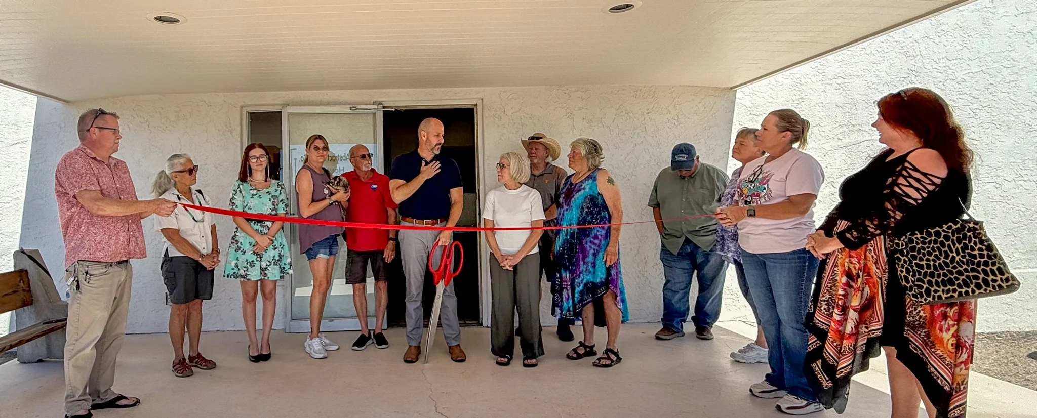 Community members gathered outside a business for a ribbon-cutting ceremony