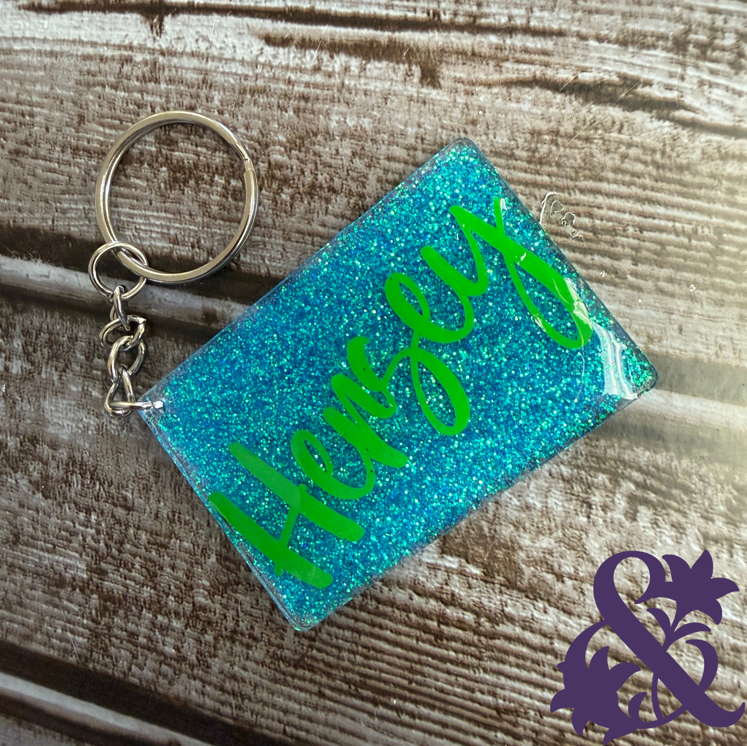 Turquoise glitter rectangular keychain personalized with the name Hersey in bright green lettering