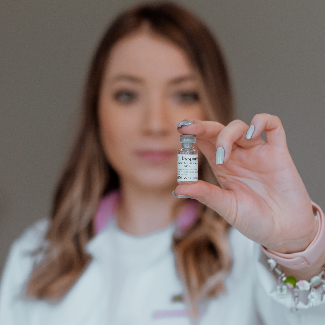 Woman holding a Botox vial toward the camera, illustrating cosmetic injection treatments