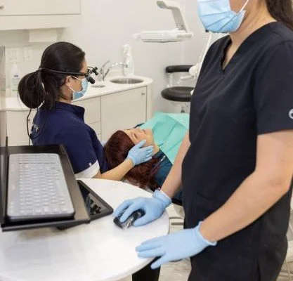 Dental staff assisting a patient in a clinic during an emergency dental visit
