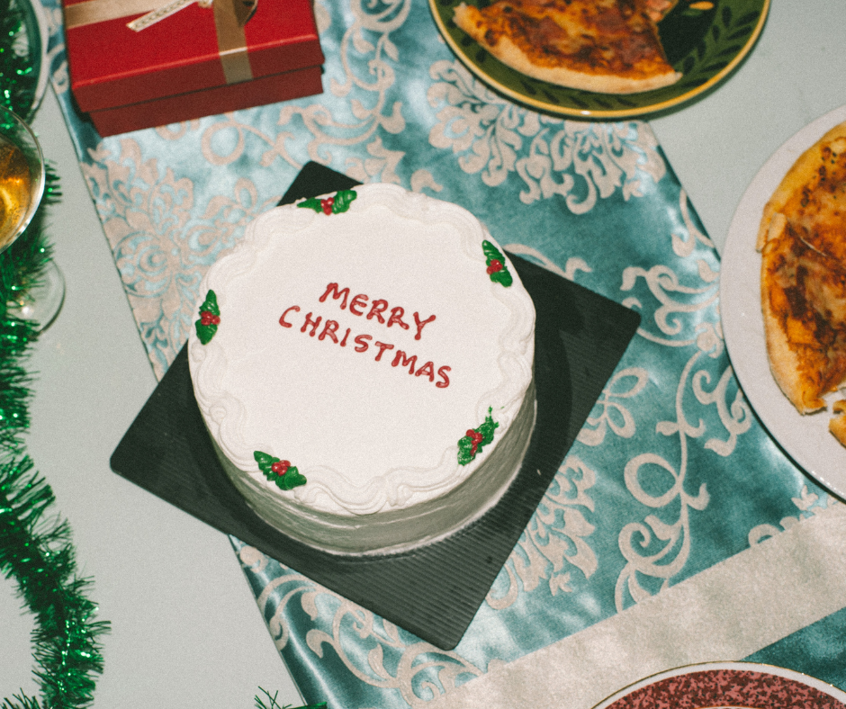 Christmas cake on a festive holiday table with gifts and food, representing December holiday season