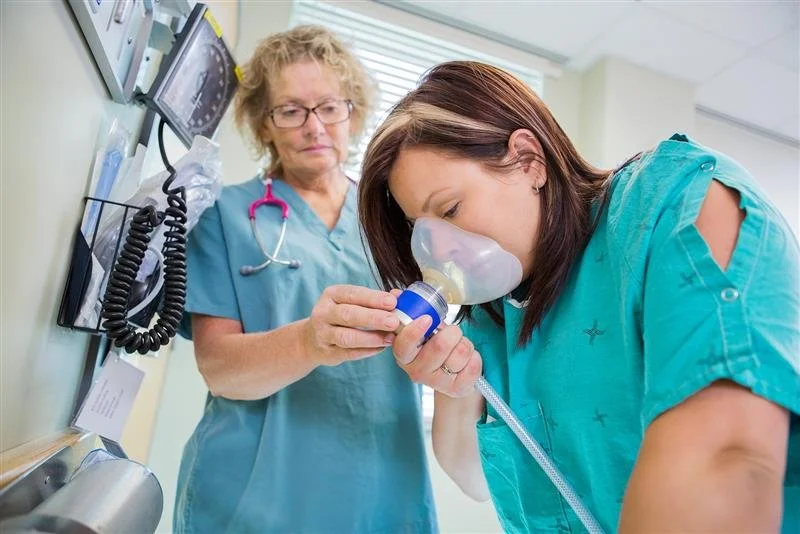 Dental professional assisting a patient with nitrous oxide sedation to provide a calm and stress-free dental experience.