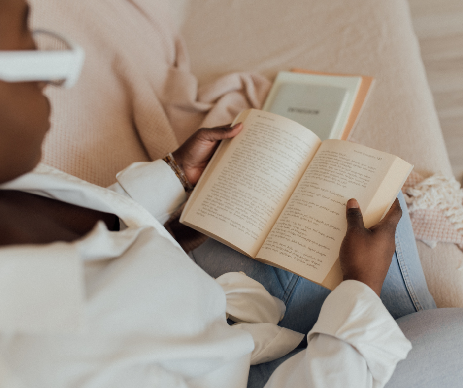 Person relaxing on a couch reading a book during recovery after tooth extraction