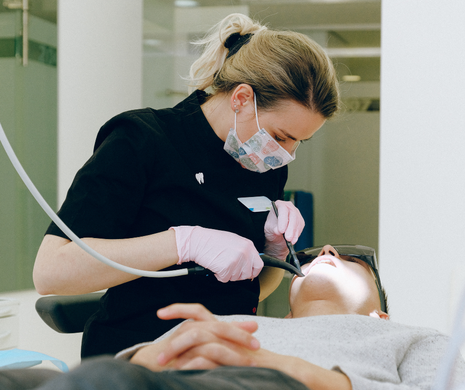 Dental hygienist performing a professional teeth cleaning on a patient during a routine dental checkup