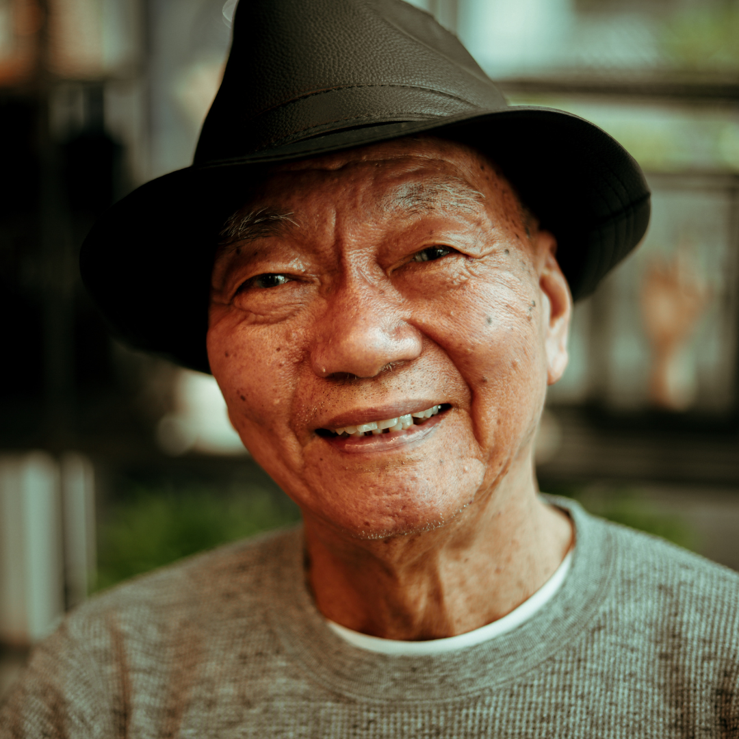 Older adult smiling outdoors, representing healthy gums and oral health