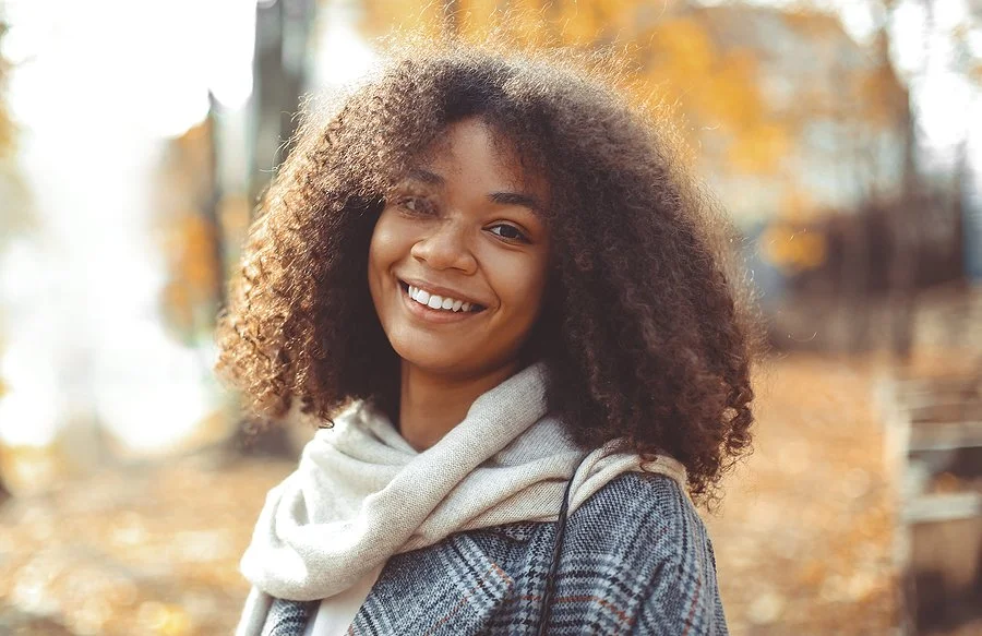 Smiling woman outdoors in autumn wearing a scarf and coat