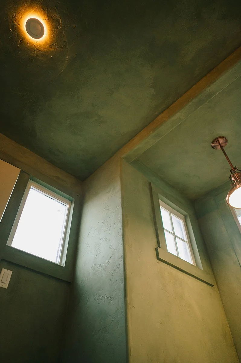 Corner detail showing handcrafted limewash texture inside a garden shed.
