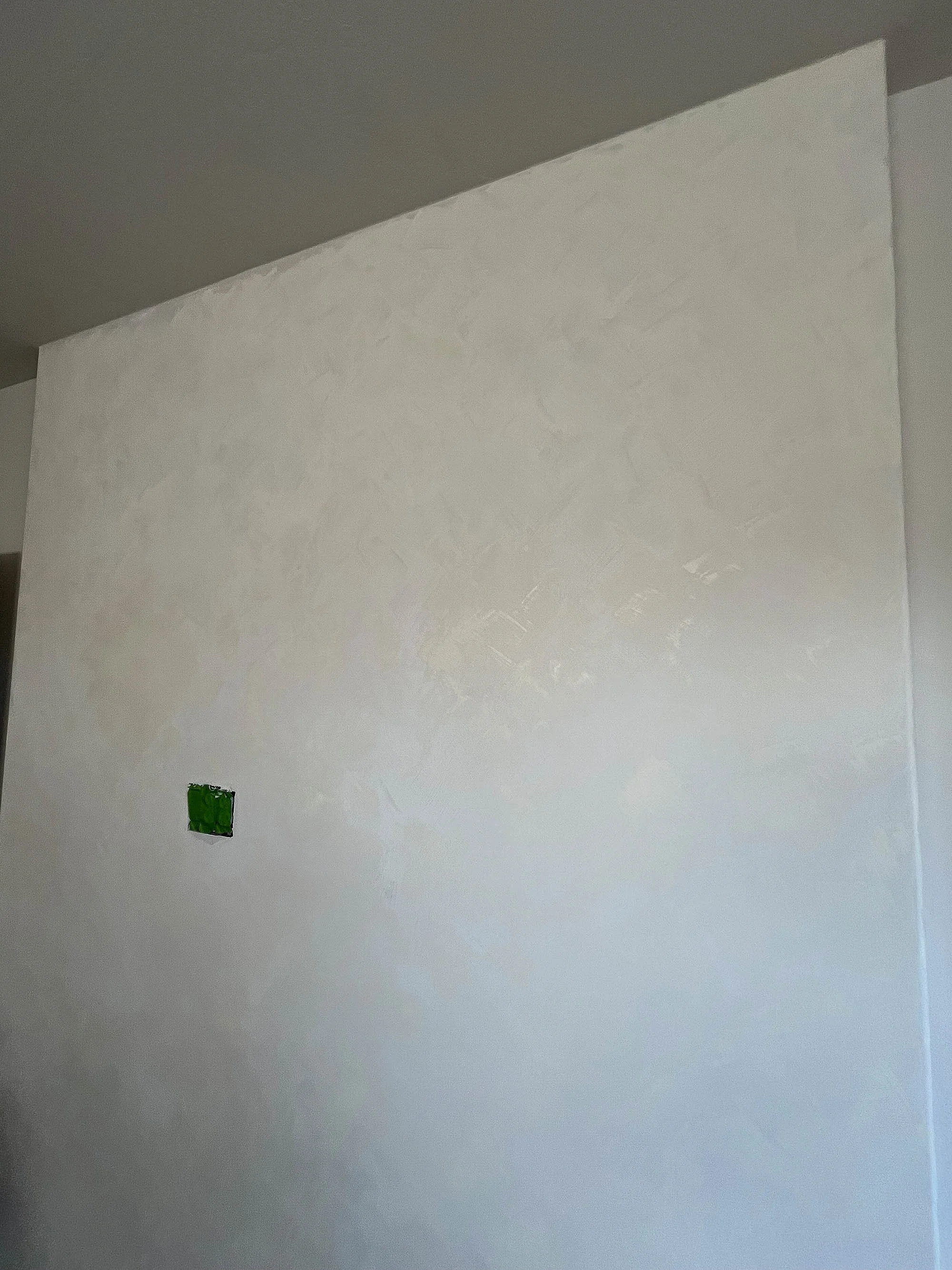 Bedroom limewash accent wall in Colour Atelier Wabi - offering a softer, balanced tone. Layered over darker shades, it adds lightness and variation, achieving a perfect artisan blend.