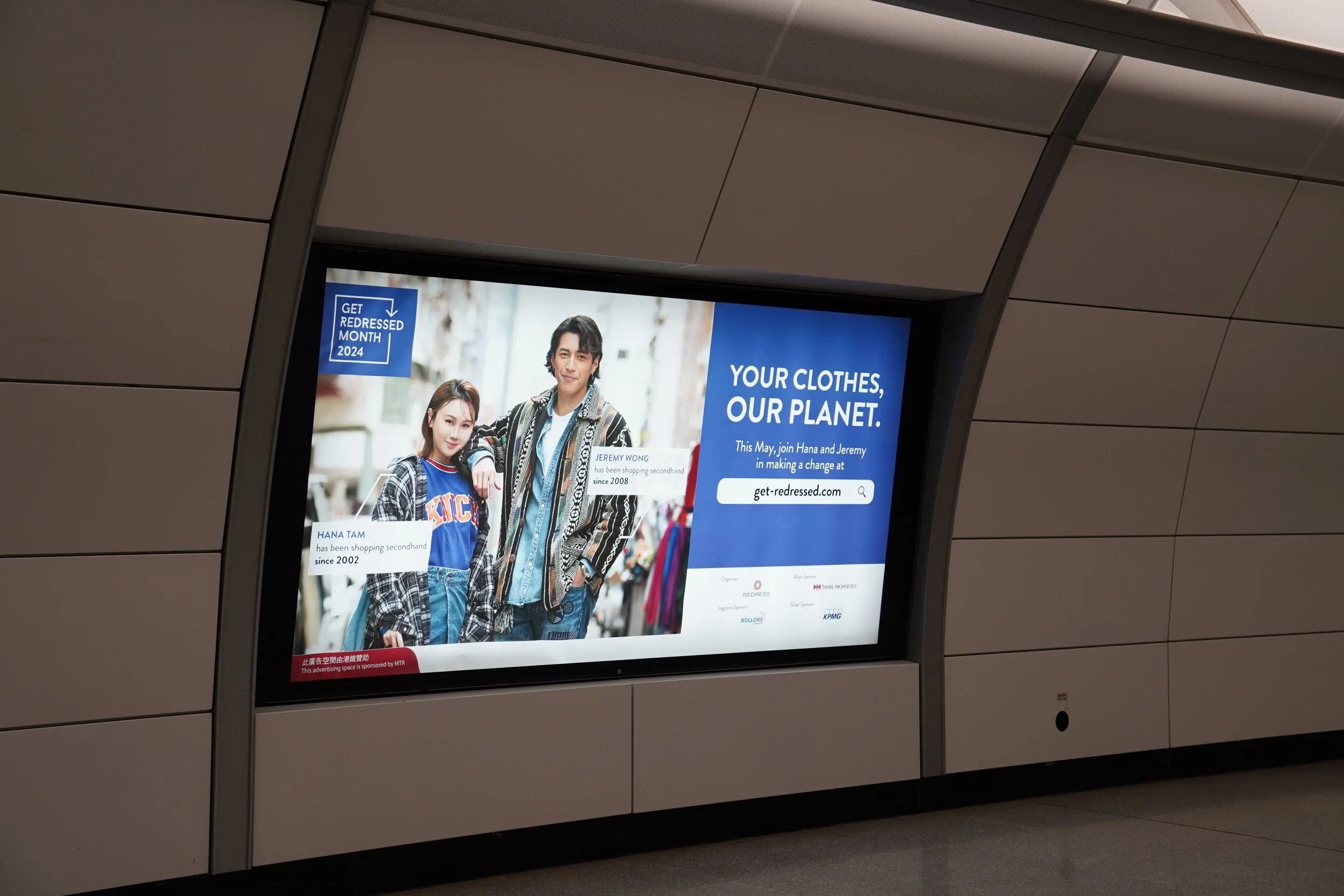 Digital advertisement featuring two young models, a woman and a man, dressed in casual streetwear, promoting an eco-friendly clothing campaign called 'Get Redressed Month 2024'. The ad includes text about shopping secondhand, their names, and a website link.