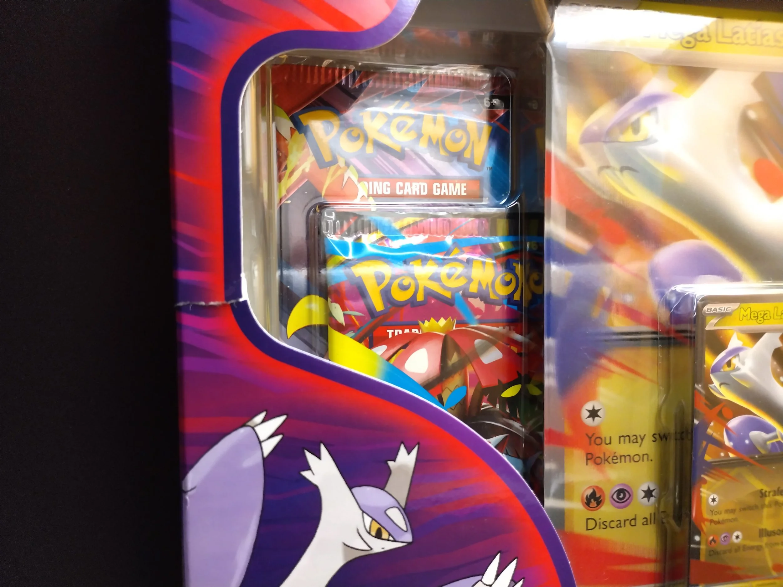 A collection of Pokémon trading card game packs inside a colourful display box with Pokémon characters on the packaging.  Example 1 of a B-Grade product.
