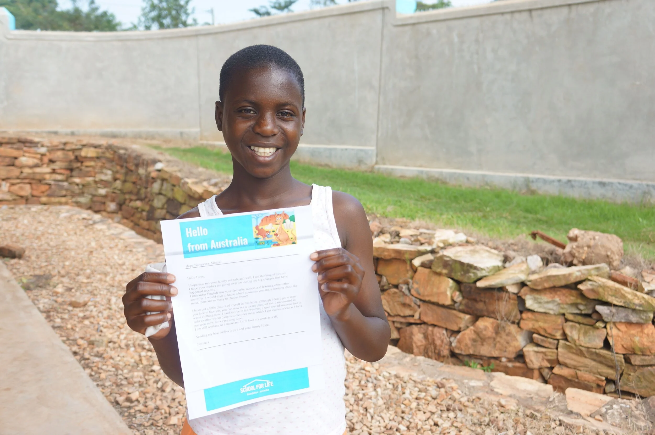 School for Life student Hope with a letter from her sponsor. 