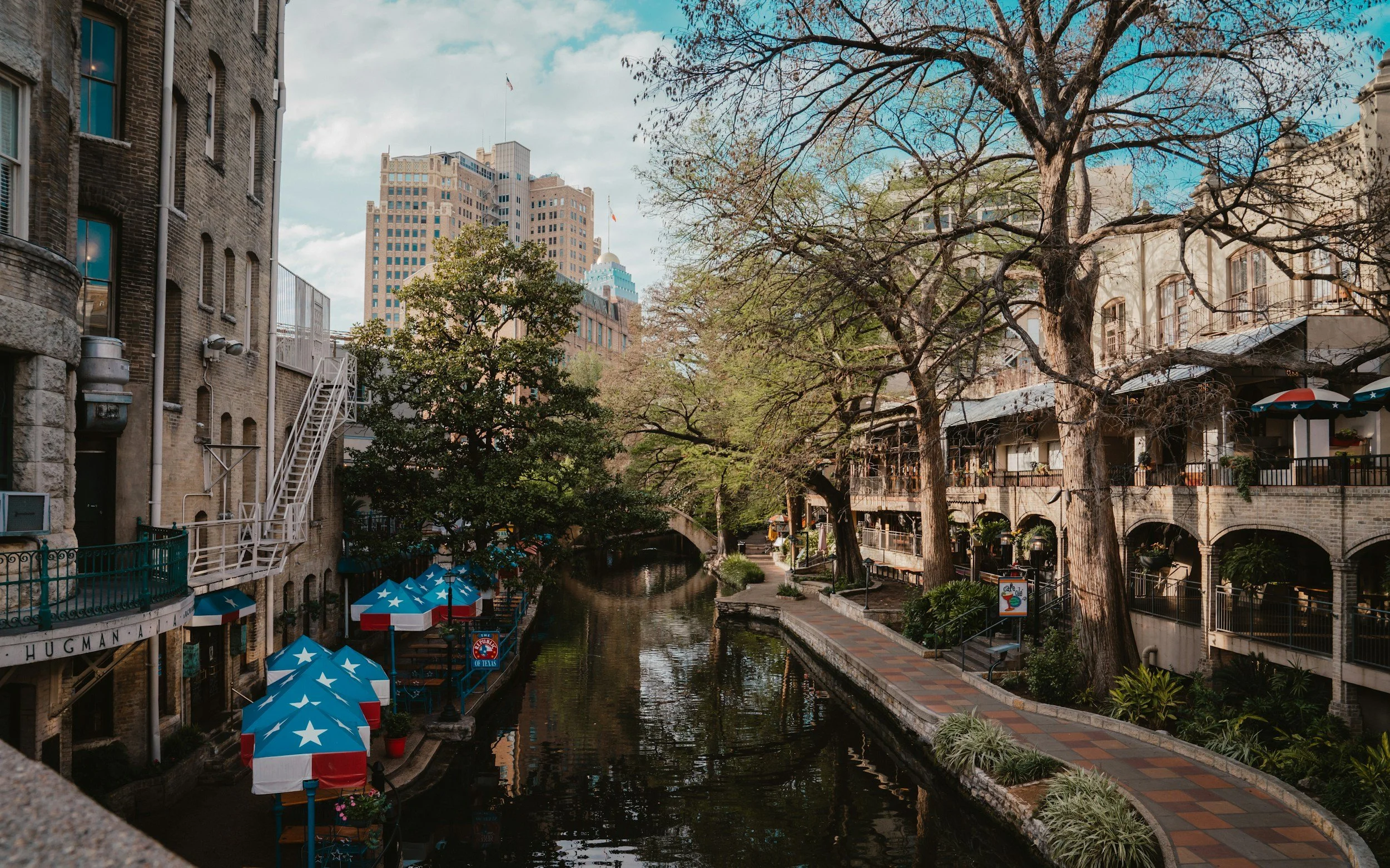 San Antonio River Walk with gondolas and restaurants lining the river.