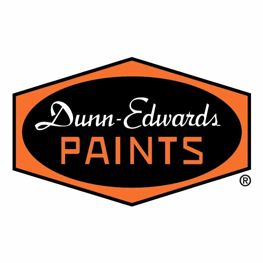 Logo for Dunn-Edwards Paints featuring a black oval with white cursive text and orange block letters, outlined in an orange hexagon.