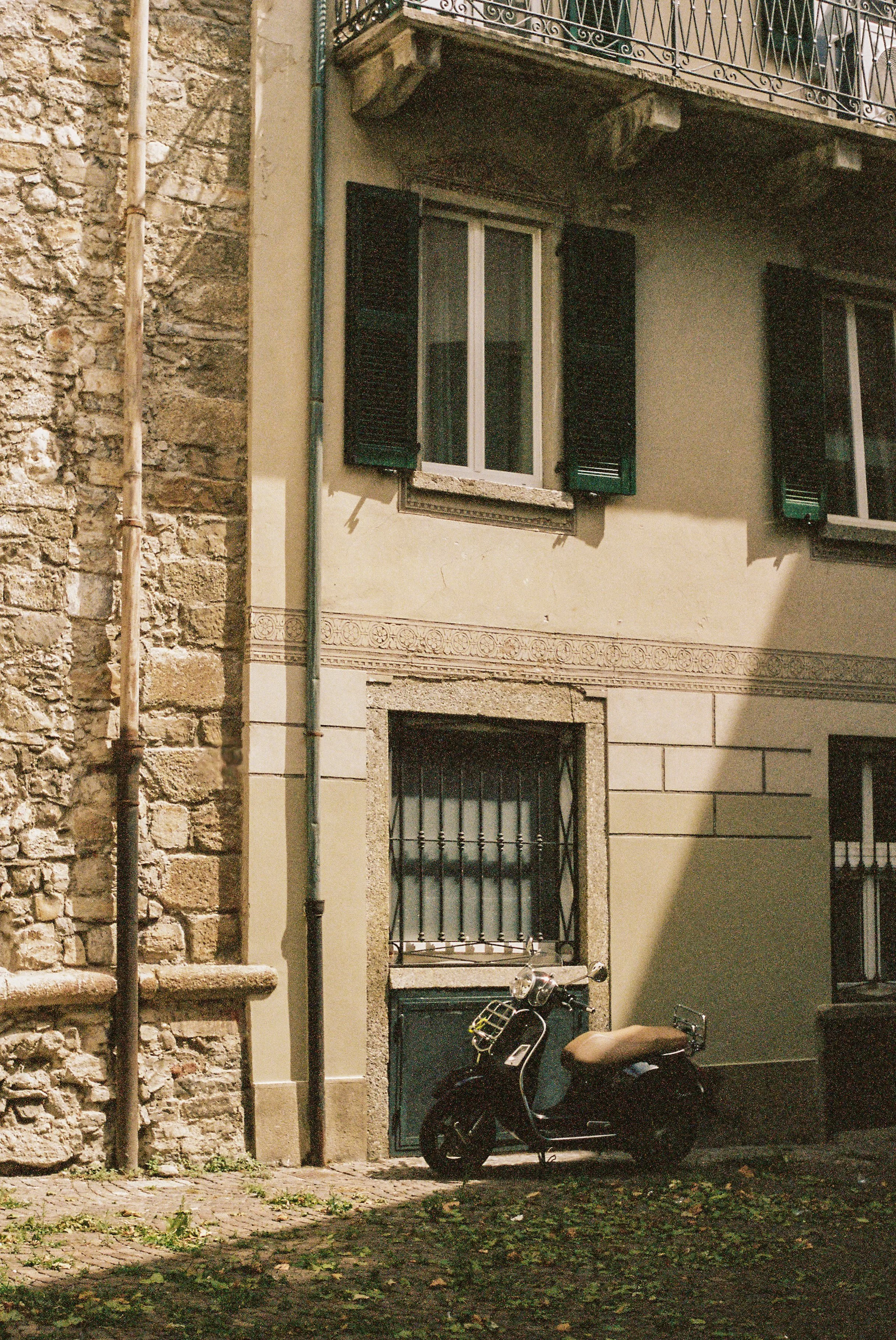 Vintage Vespa parked on cobblestone street beside historic building in Lecco, Lake Como, Italy — Italy travel photographer and film photographer Anna Hudson