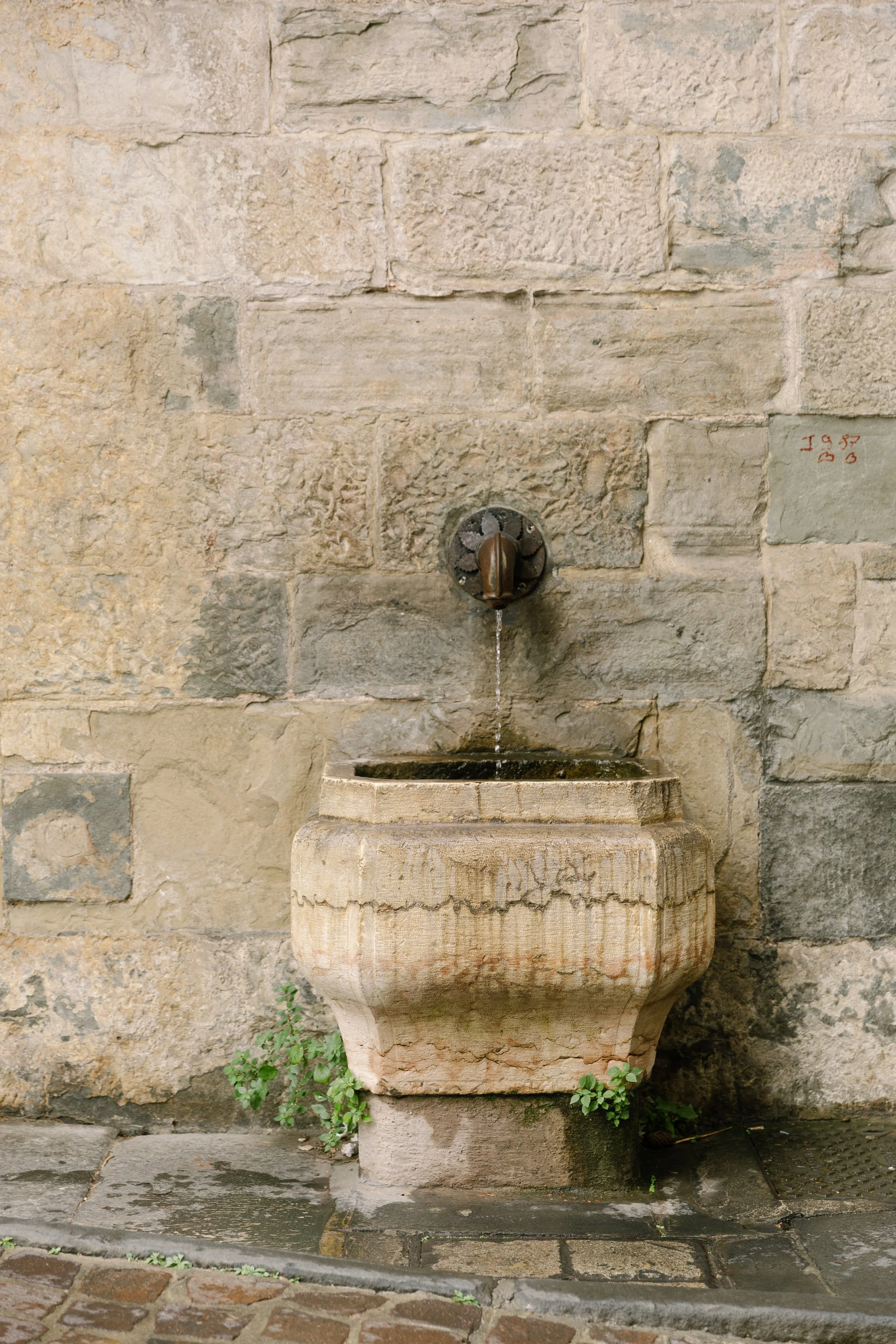Ancient marble wall fountain with bronze spout on a historic stone wall in Bergamo Alta, Lombardy, Italy — Italy travel photographer Anna Hudson