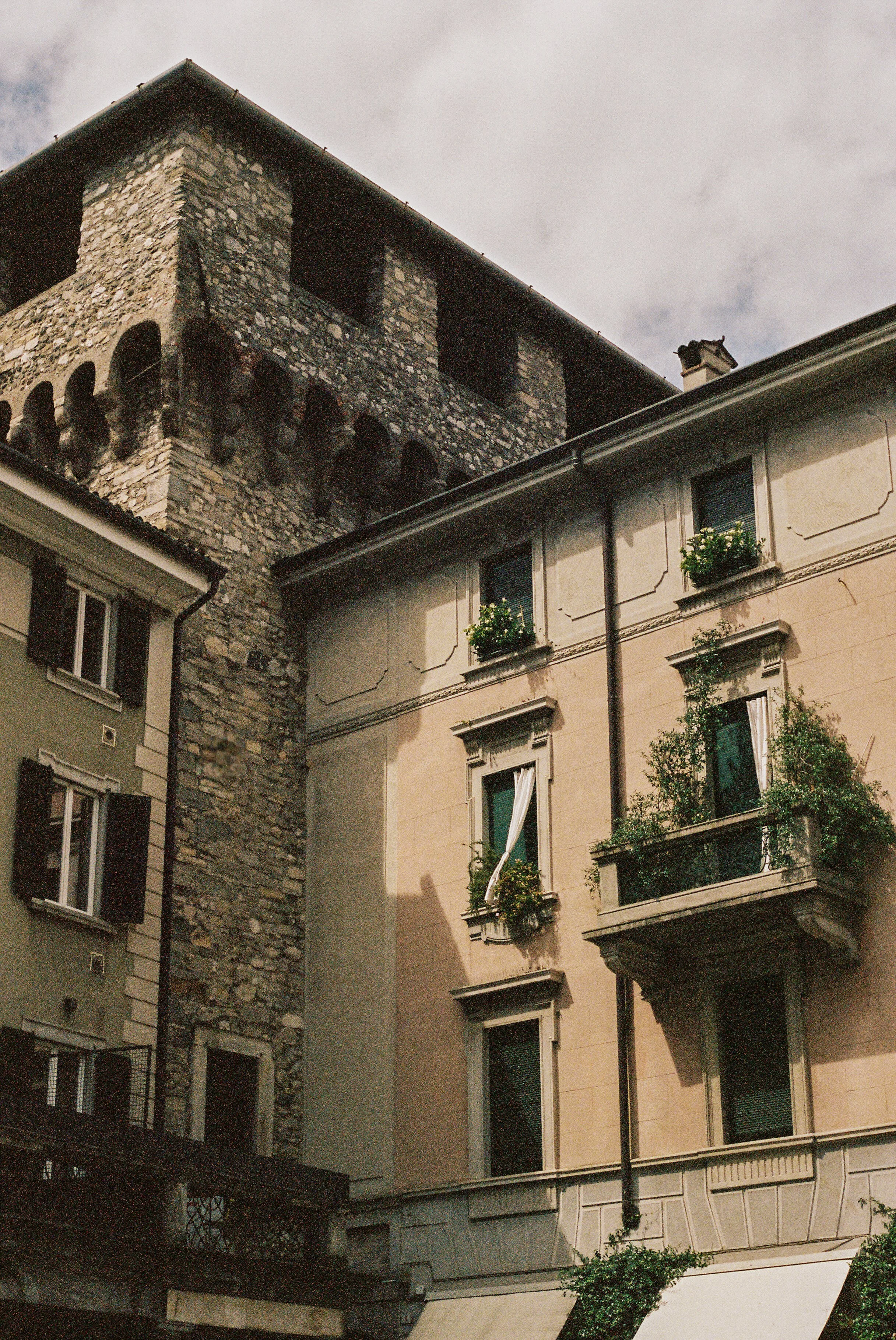 Torre Viscontea medieval tower and historic apartment building with flower balconies, Lecco, Lake Como, Italy — Italy travel photographer and film photographer Anna Hudson