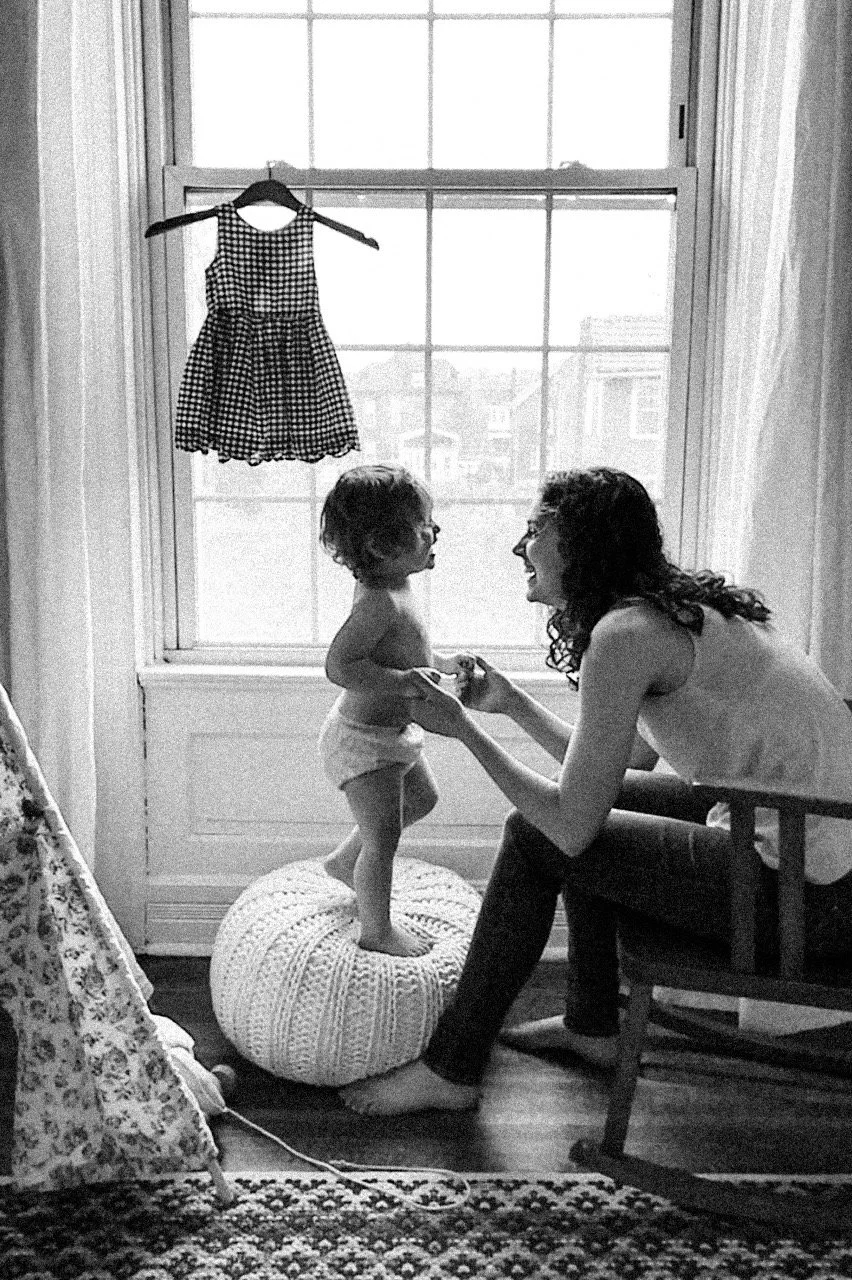Black and white film photograph of a mother laughing with her toddler during an in-home family session — Colorado lifestyle family photographer Anna Hudson
