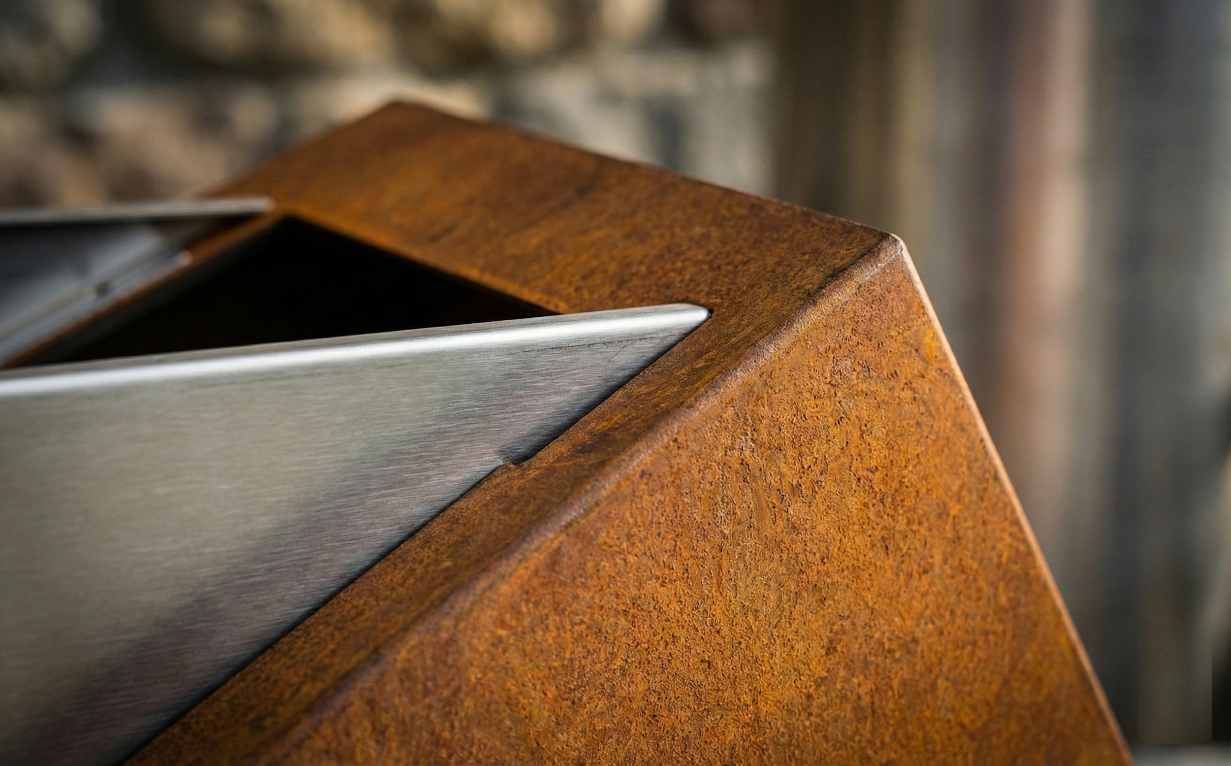 Dettaglio texture materica fioriera Truss: primo piano sul contrasto tra la patina naturale del Corten e l'eleganza dell'acciaio inox satinato