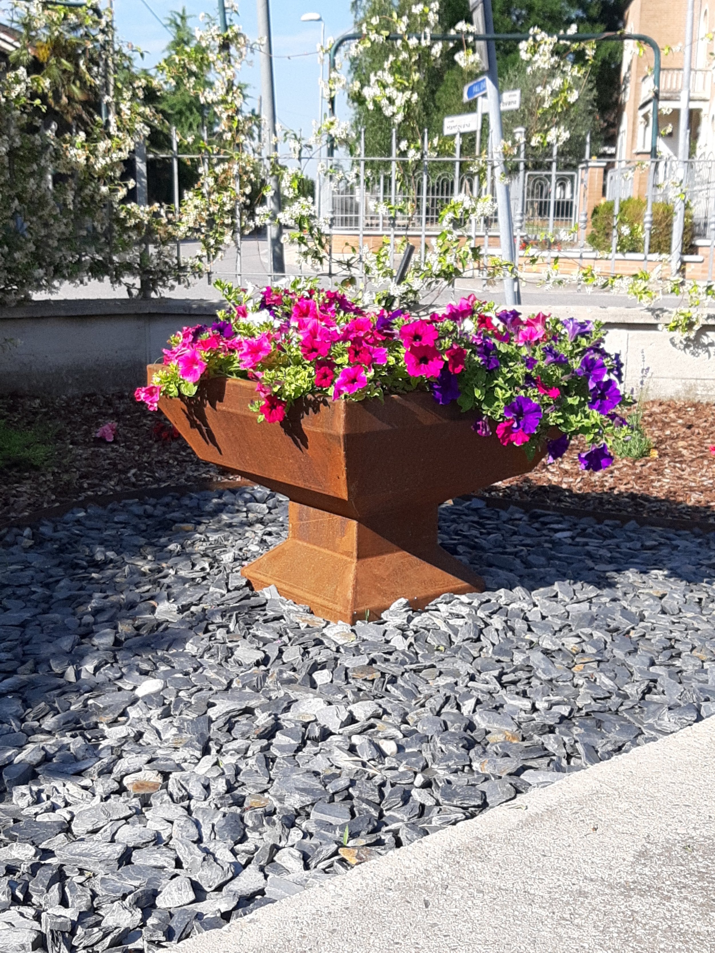 Fioriera per arredo urbano in Corten modello Keystone, elemento resistente su ghiaia per progetti di landscape design in parchi e spazi pubblici