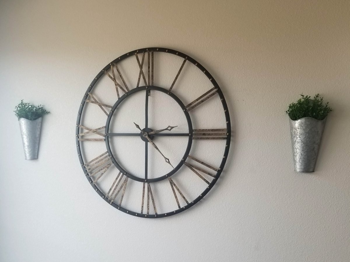 Large wall clock and planters hung level in a Phoenix home
