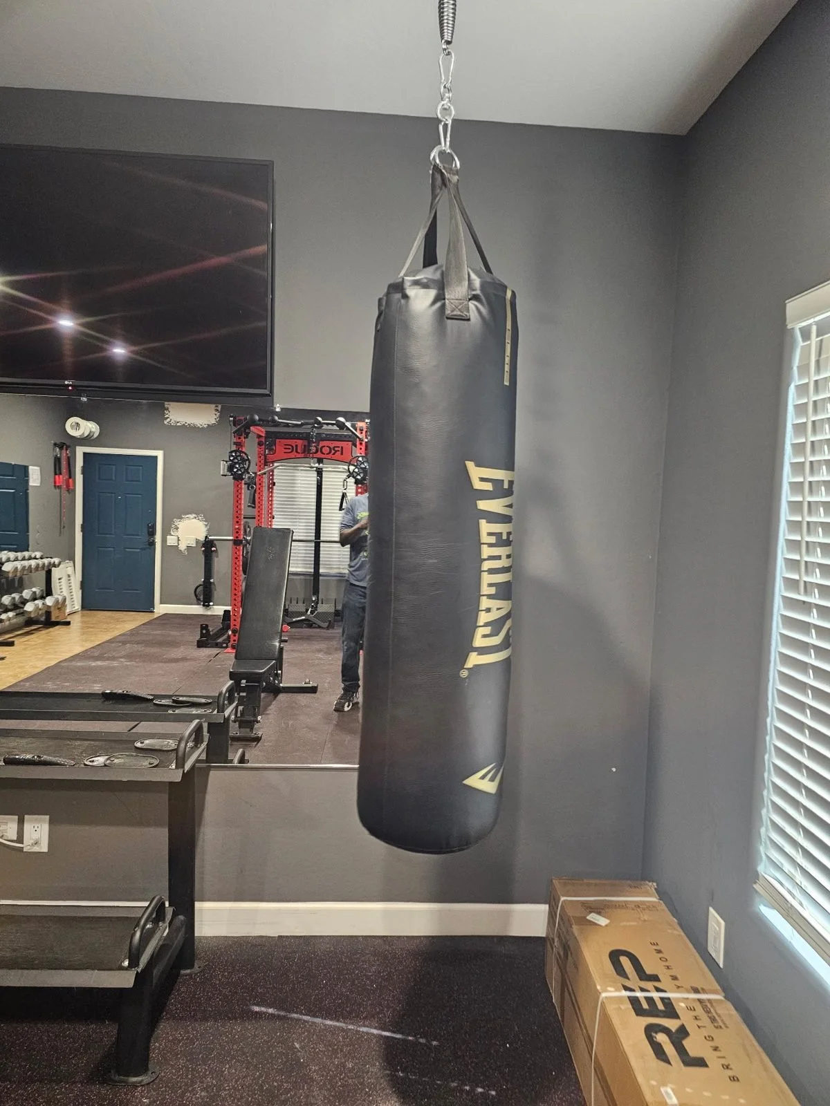 Everlast heavy bag hung from a ceiling mount in a Phoenix home gym