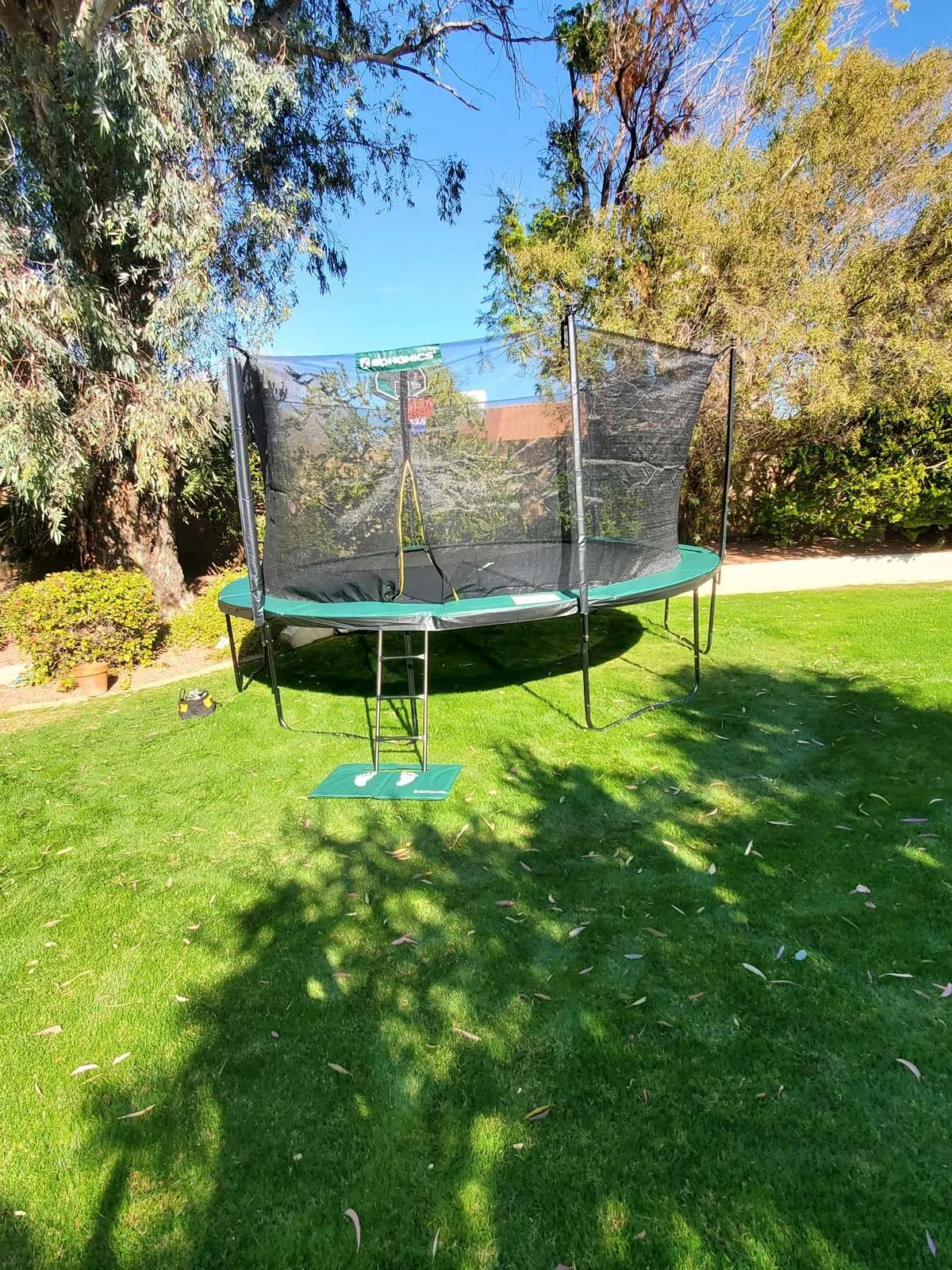 Round trampoline with safety net assembled on a Paradise Valley lawn