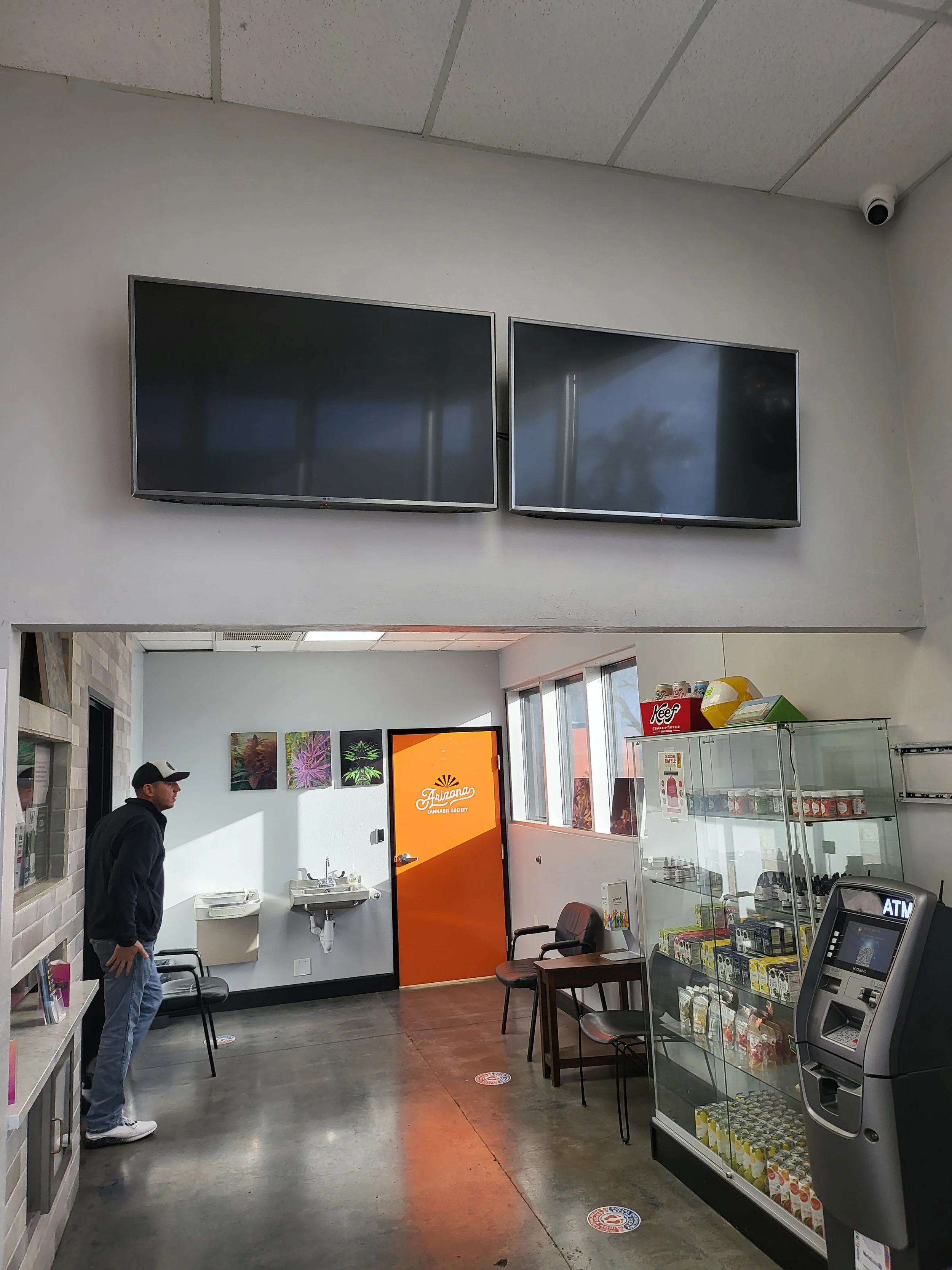 Commercial digital menu board installation inside a Phoenix cannabis dispensary, featuring flush-mounted retail displays, commercial-grade steel wall brackets, and clean wire management.