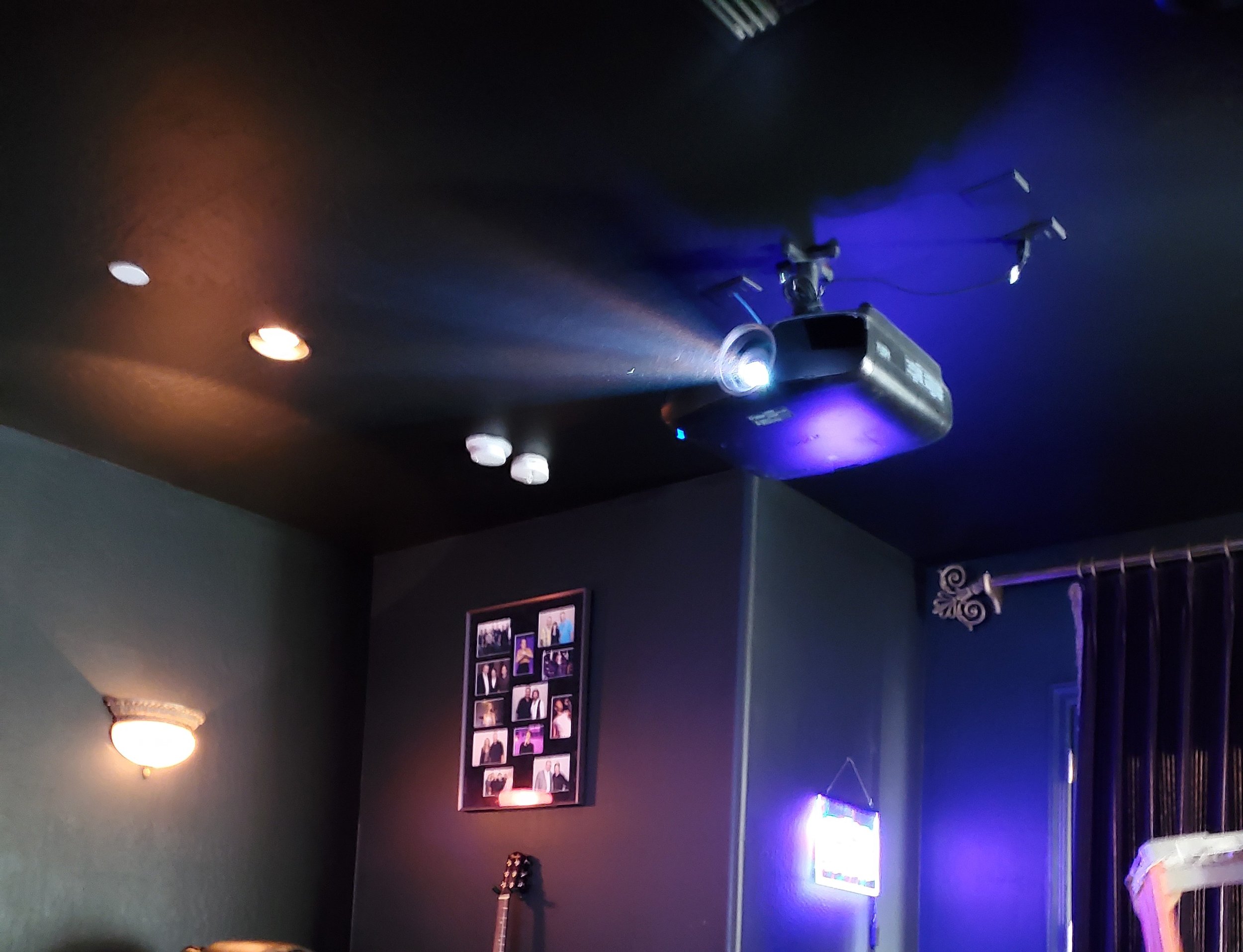 Precision ceiling-mounted home theater projector installation in a custom Phoenix media room, featuring calibrated throw distance, concealed ceiling wiring, and ambient theater lighting.