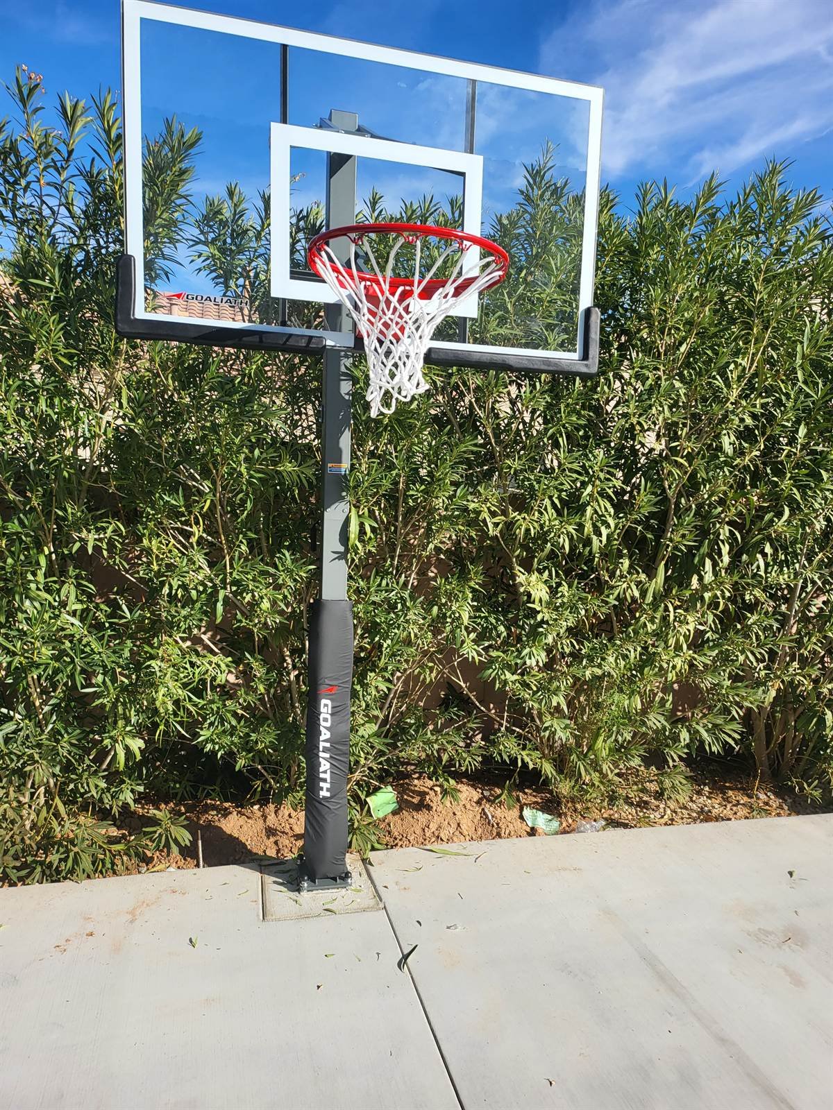 Goaliath in-ground basketball goal with glass backboard installed on a Chandler concrete slab