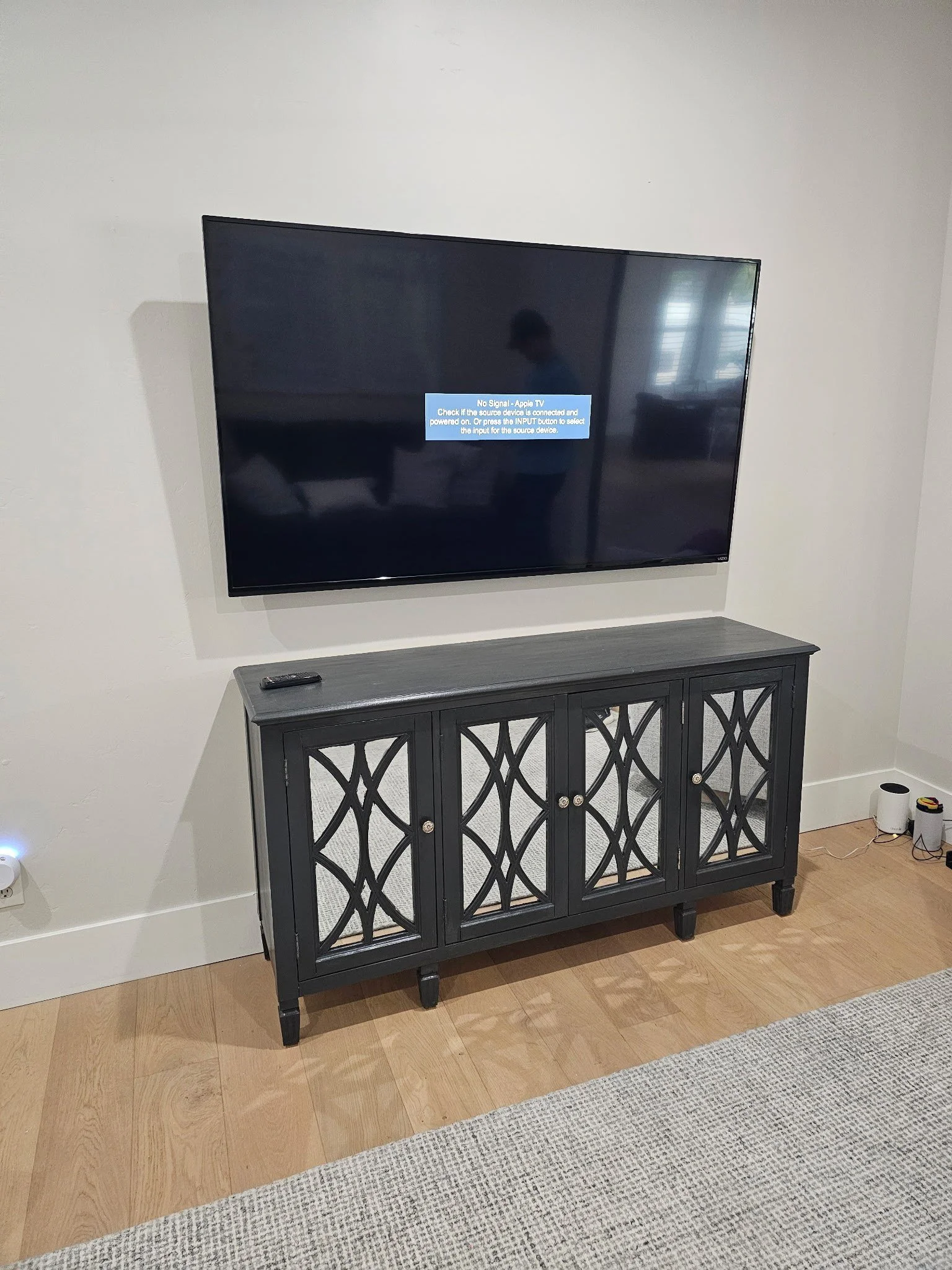 TV wall mounted above a mirrored media console in a Phoenix living room