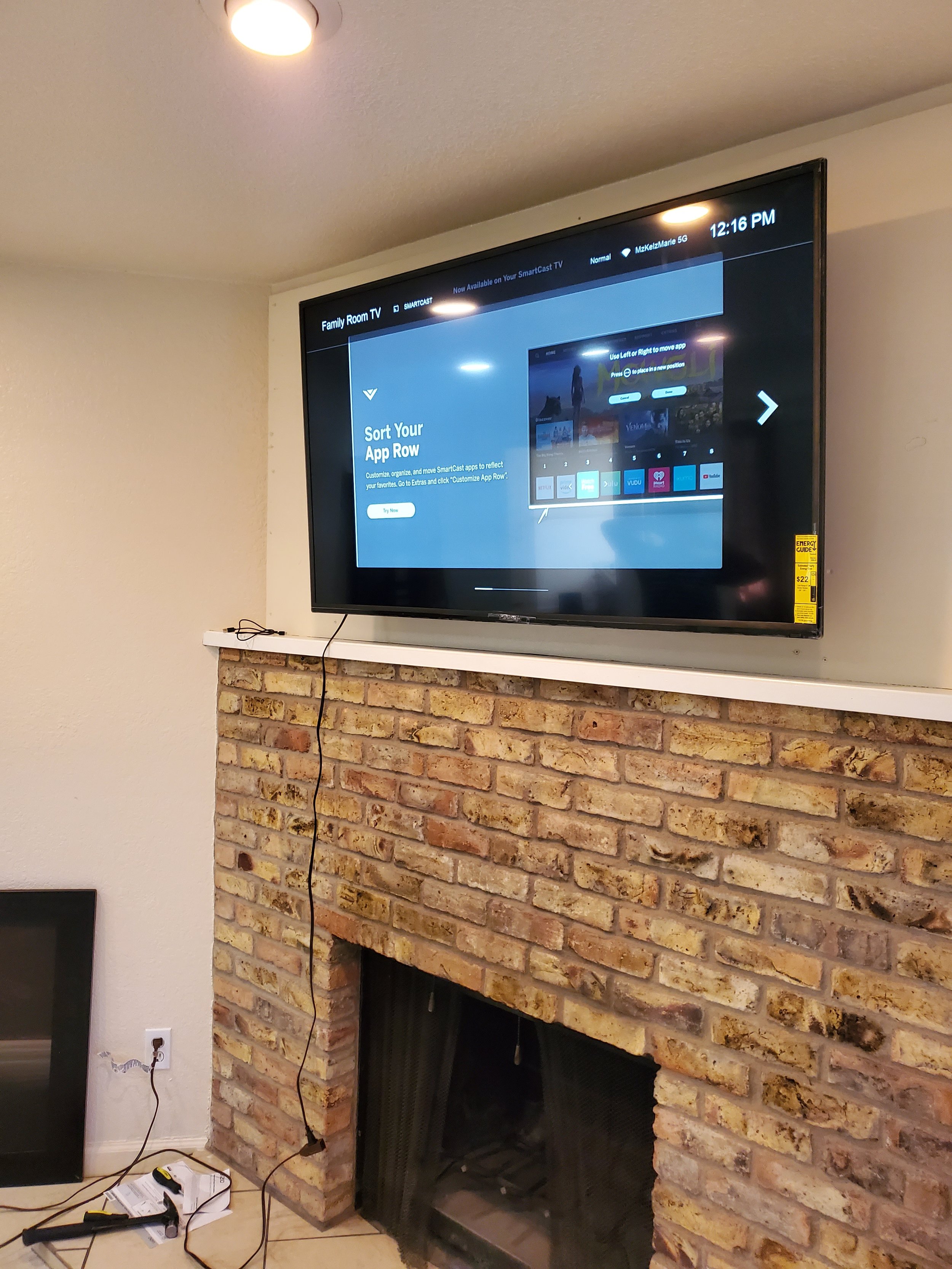 Professional TV wall mounting above a tan brick fireplace in Phoenix, AZ featuring heavy-duty masonry anchoring and secure stud mounting.