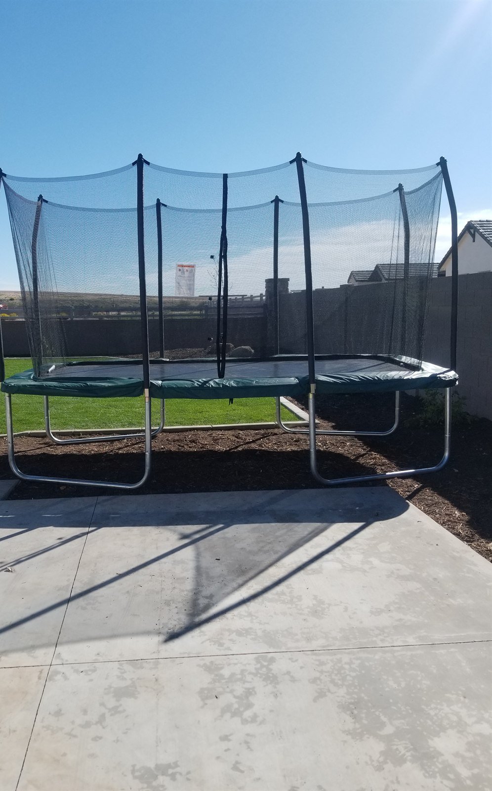 Rectangular trampoline with safety net assembled in a Cave Creek backyard