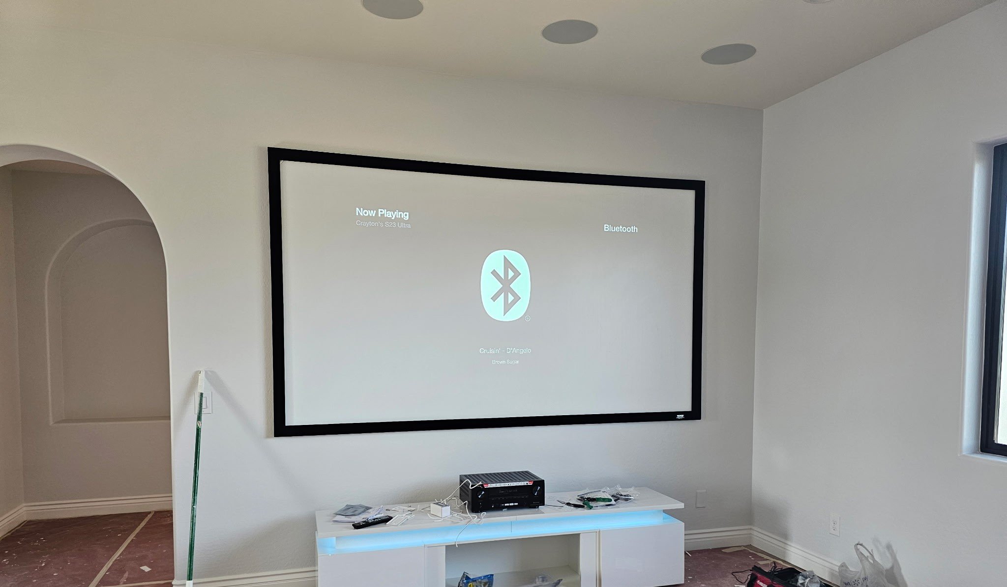 Professional fixed 120" projector screen installation for a clean, permanent home theater setup with precise alignment and secure mounting.
