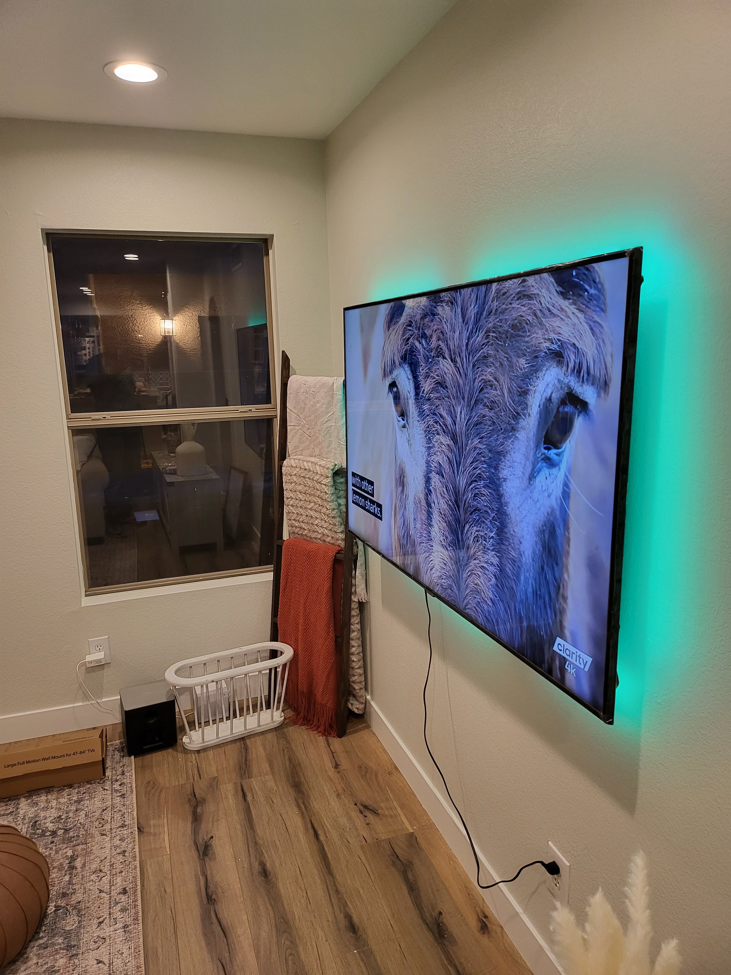 Flat-screen television mounted above a black fireplace insert in a Phoenix living room, flanked by built-in white display shelving with complete concealed cable routing.
