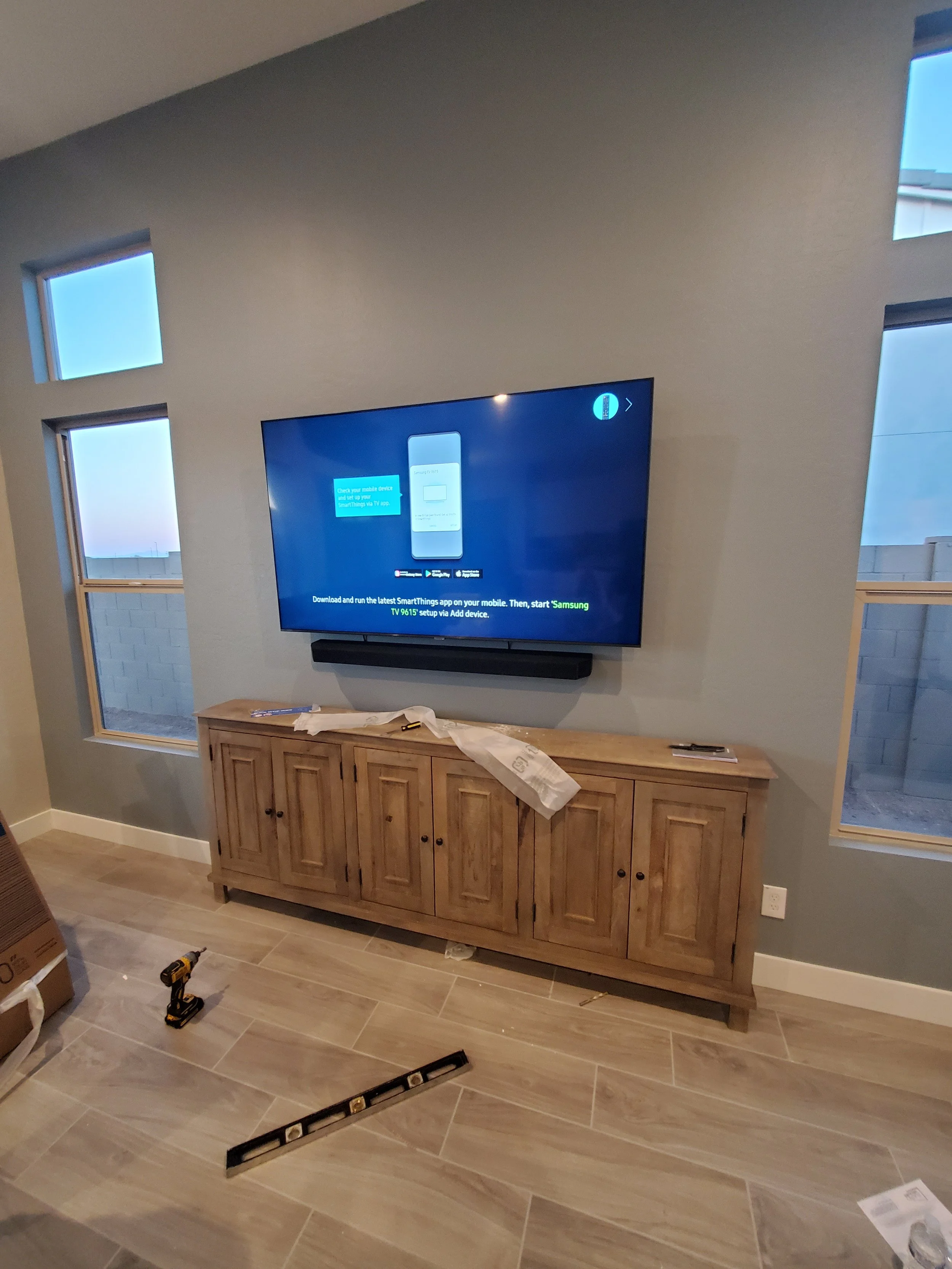 Professional TV and soundbar wall mounting in a Phoenix living room, seamlessly integrated above a media center with complete in-wall wire concealment.