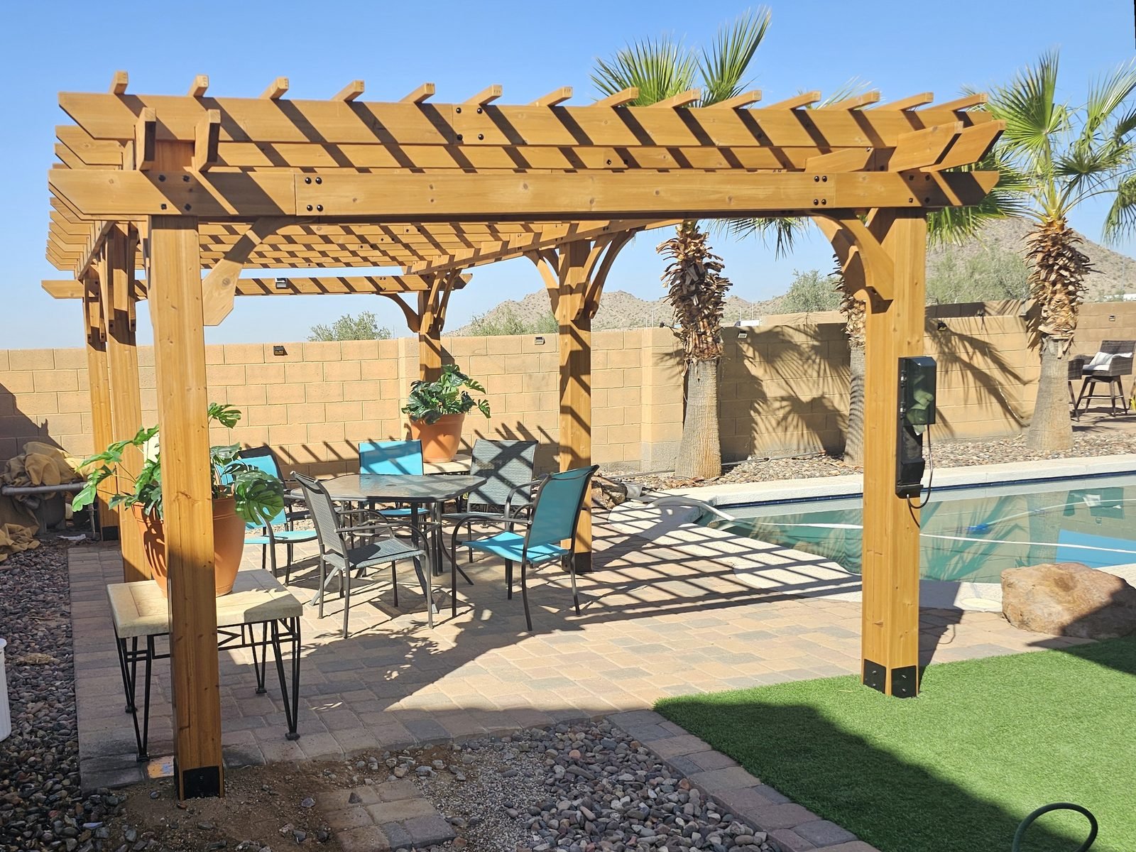 Cedar wood pergola installed by Helping Hands pergola installers over a backyard patio in Phoenix