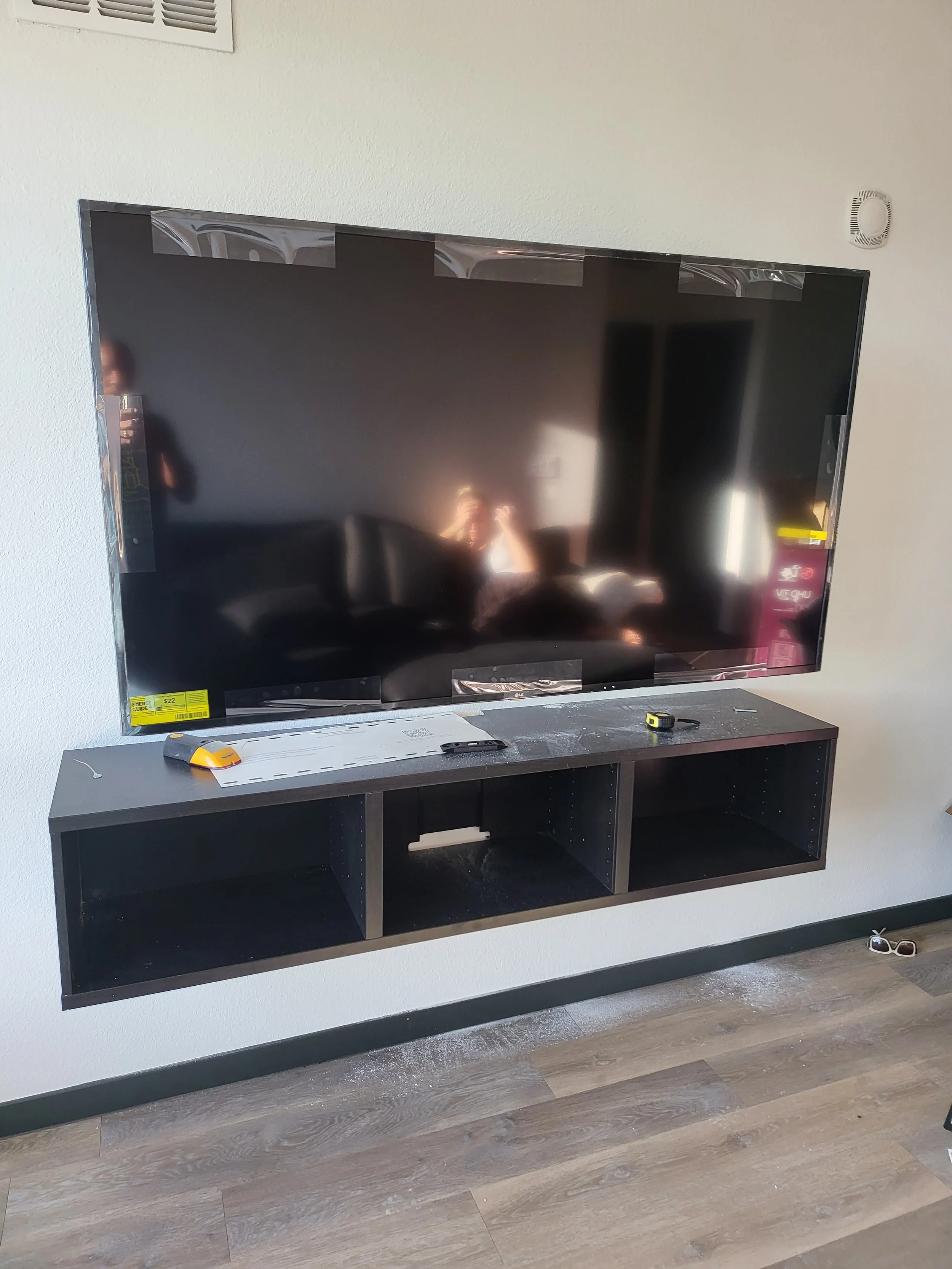 IKEA BESTÅ floating media console assembly paired with a wall-mounted flat-screen television in a Phoenix living room, featuring clean floating storage and complete behind-wall wire concealment.