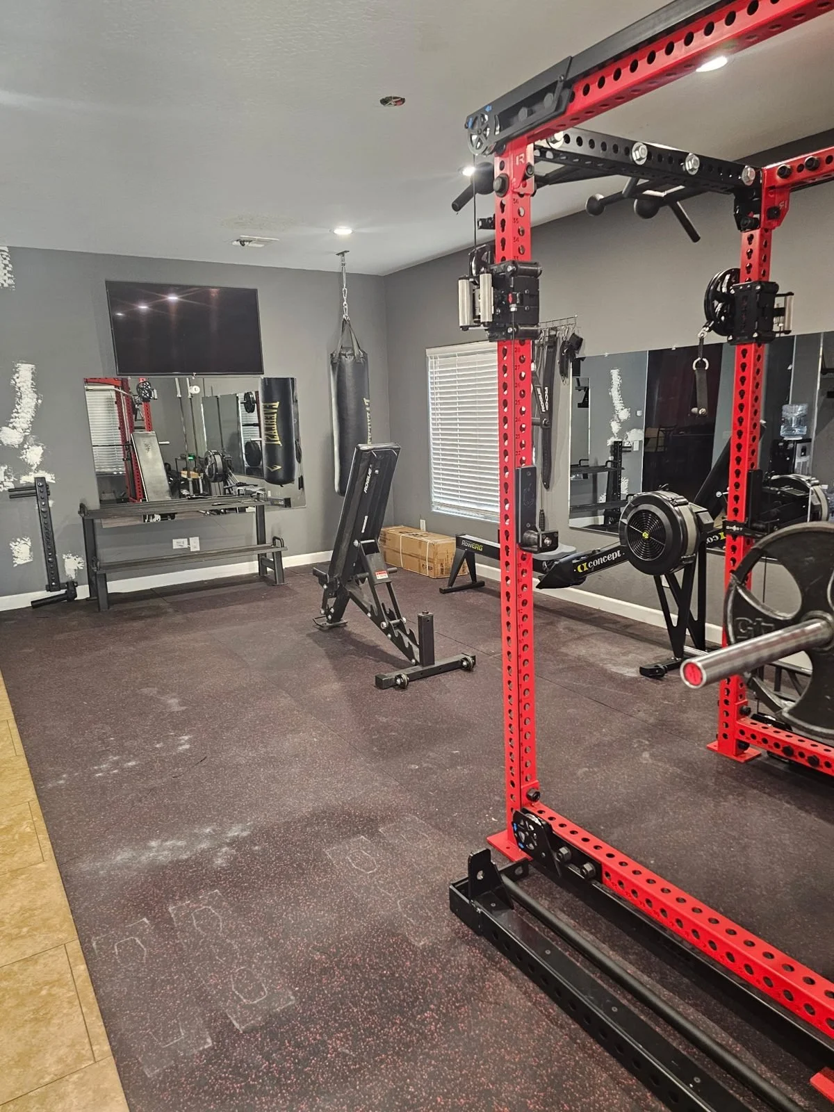 Home gym with Rogue power rack, bench, heavy bag and rower installed in Phoenix, AZ